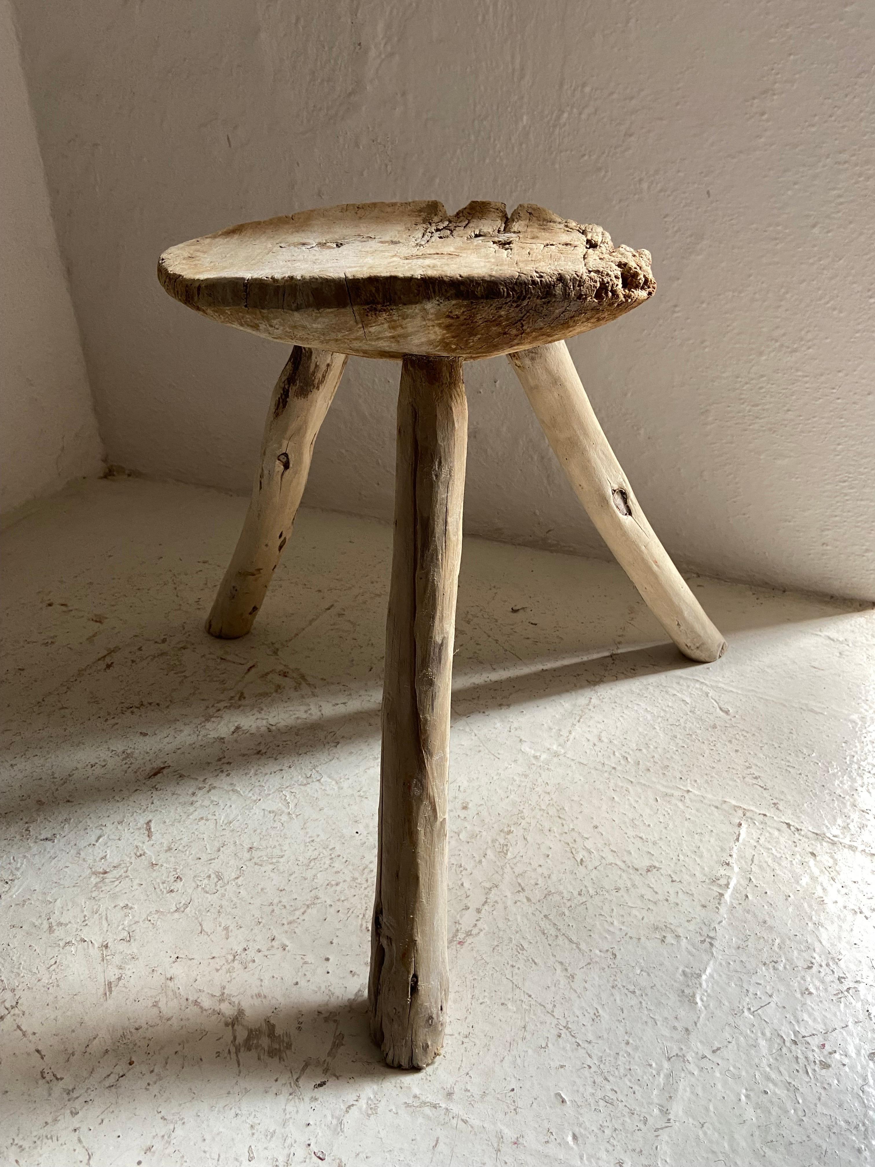 Mid-20th Century stool from San Luis Potosí, Mexico made from Sabino wood. This stool is Primitive in design and shows significant wear or distress on one side of the seat.