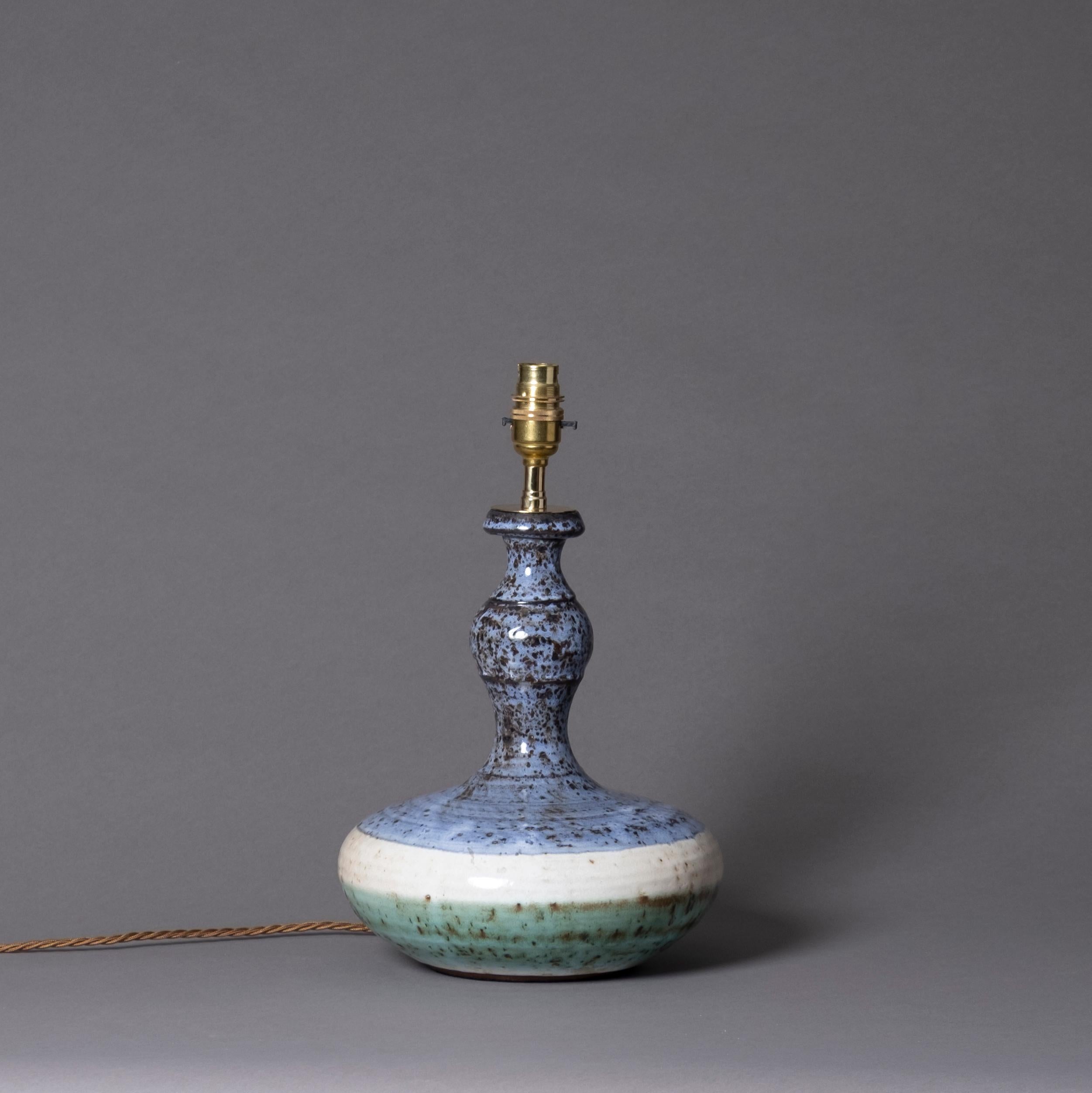 A mid-20th century studio pottery vase of bottle form with mottled blue, cream and green glazes. Now wired as a table lamp

Height dimensions refer to height of pottery vase only.

Wired and tested for UK safety standards. This item can be