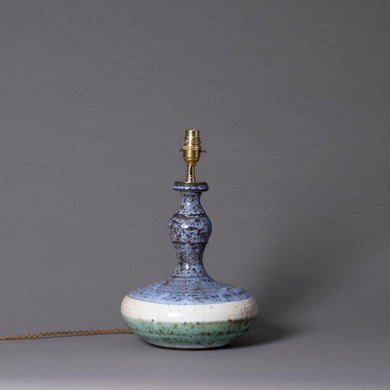 A mid-20th century studio pottery vase of bottle form with mottled blue, cream and green glazes. Now wired as a table lamp

Height dimensions refer to height of pottery vase only.

Wired and tested for UK safety standards. This item can be