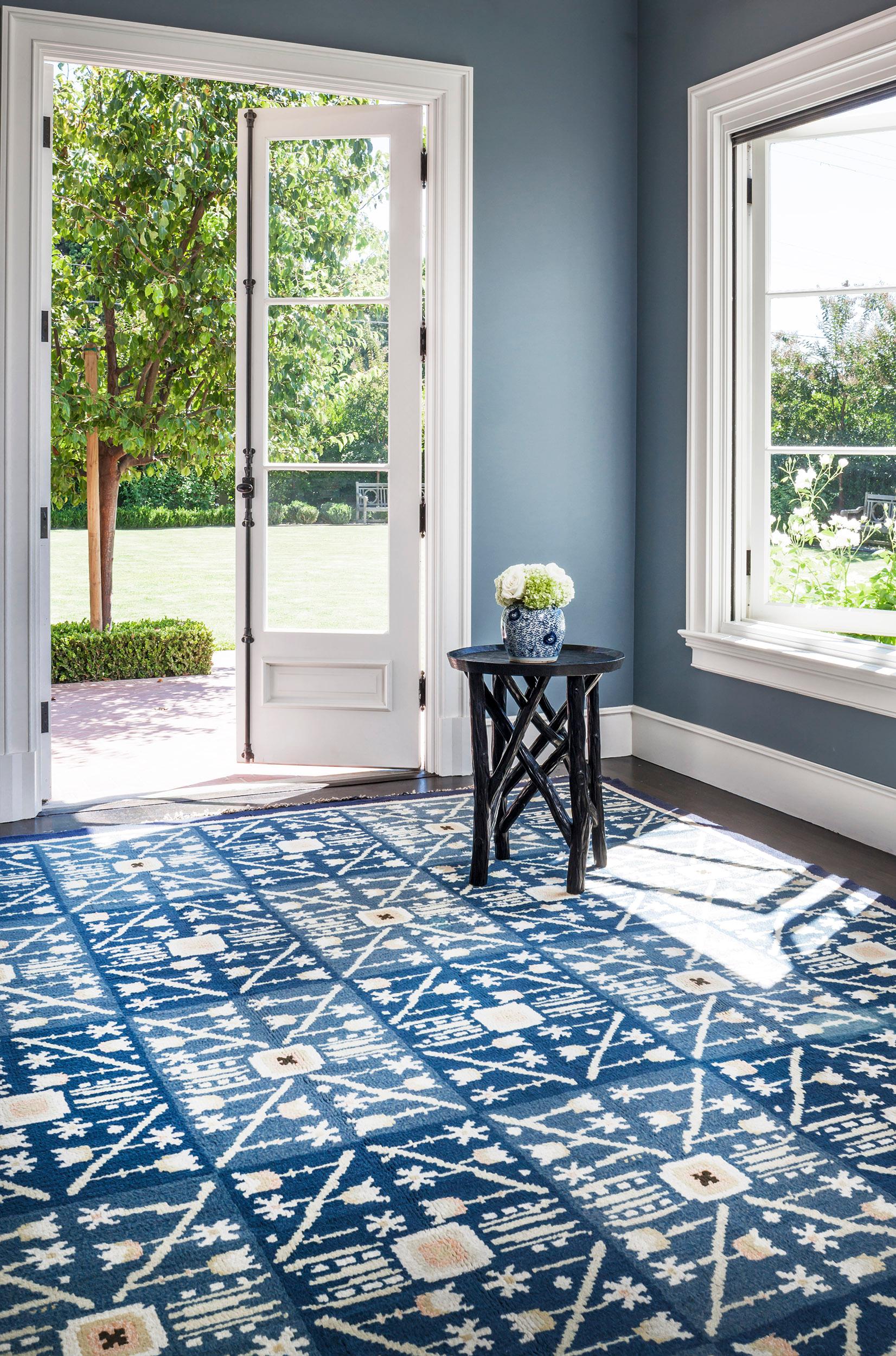 Dieser handgewebte schwedische Deko-Teppich im Vintage-Stil hat ein königsblaues, tonal kariertes Feld, das von feinen geometrischen Blütenköpfen überlagert wird, die zarte, gewinkelte Blumenranken bilden, die ein Rautengitter bilden, das von