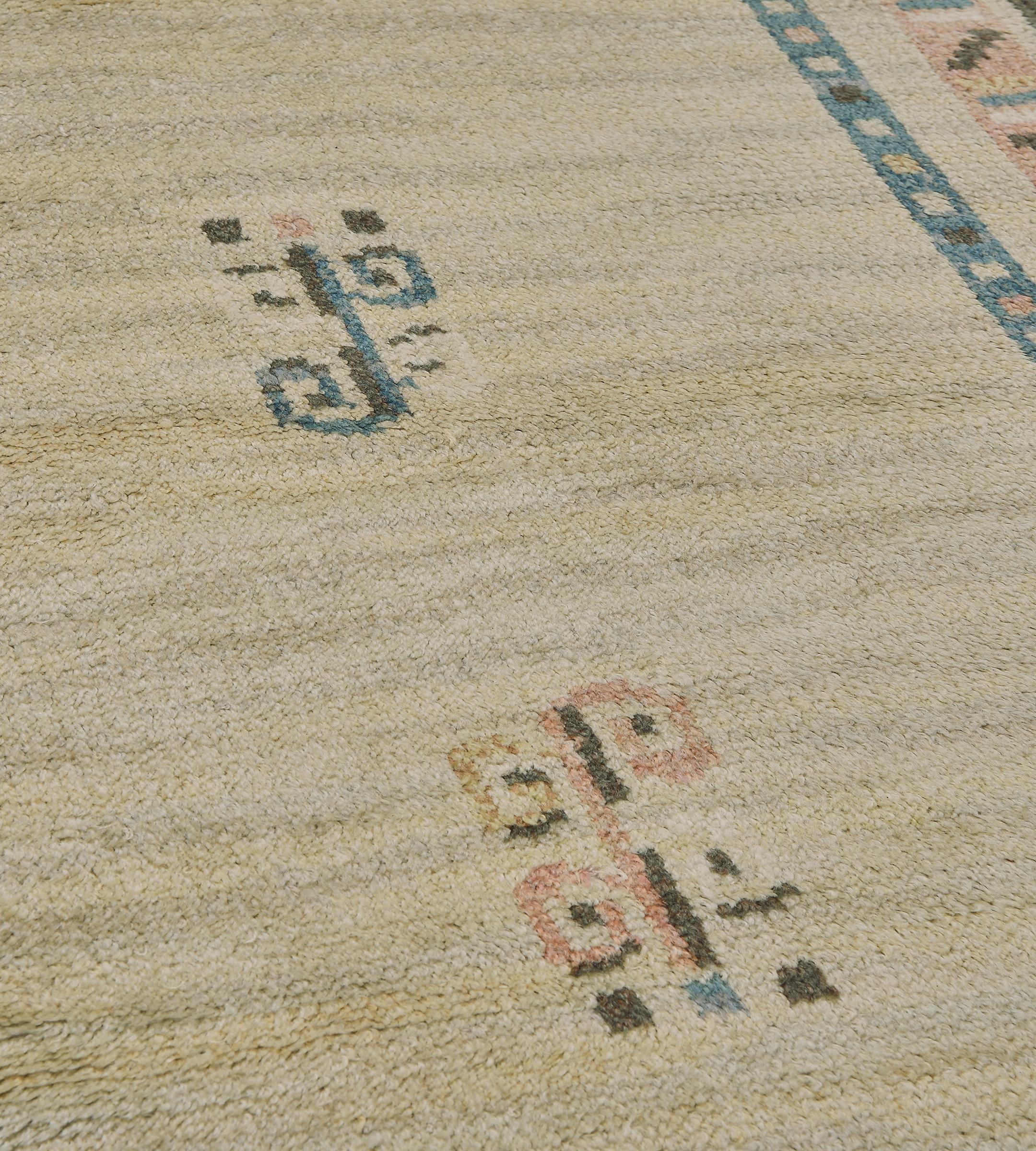 Questo tappeto vintage Swedish Deco tessuto a mano presenta un campo aperto avorio con un delicato motivo di gambi arricciati e due eleganti pannelli blu navy contrapposti con un motivo simile, in un raffinato bordo geometrico color ruggine.