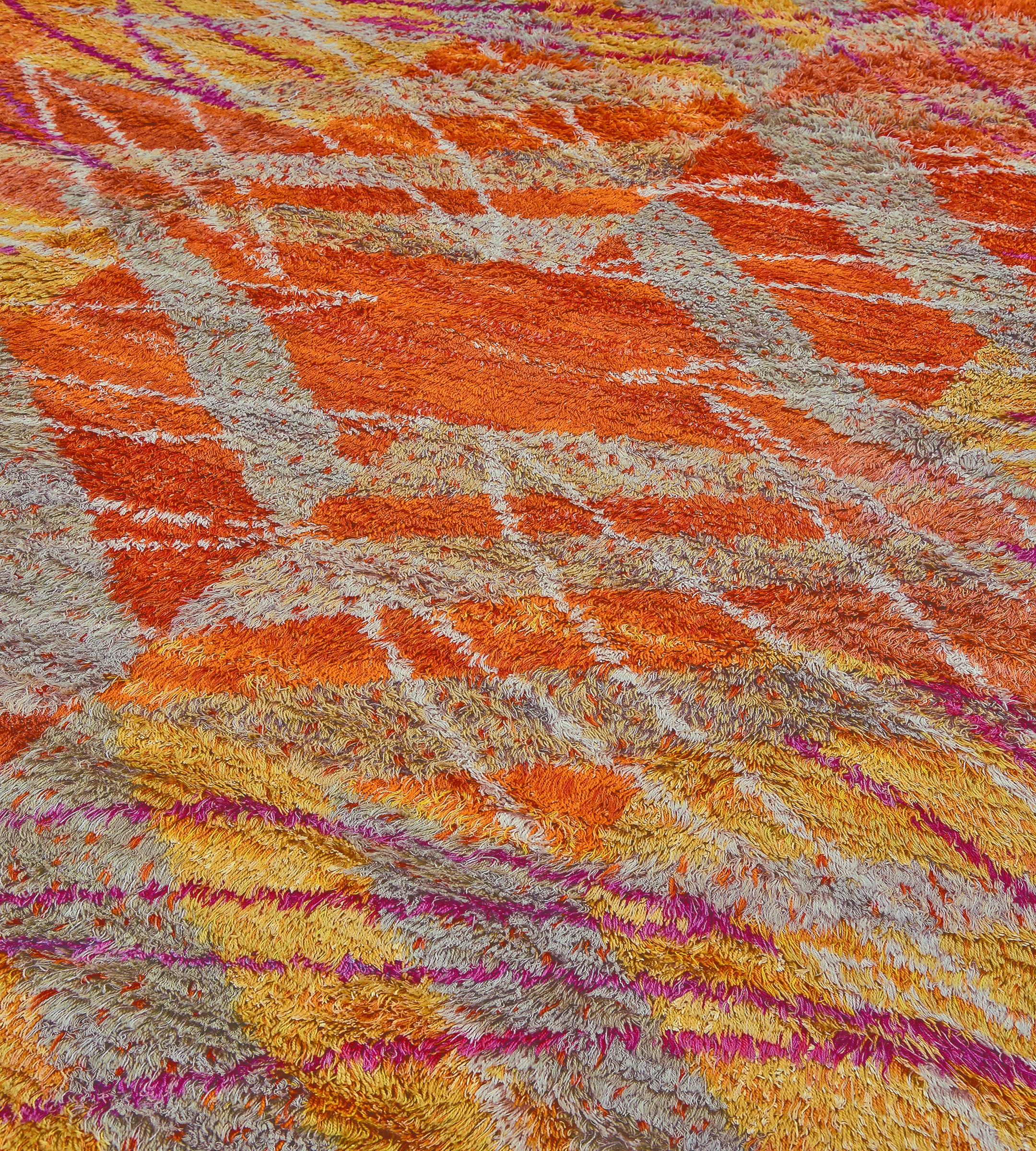 Questo tappeto vintage a vello profondo tessuto a mano in stile deco svedese presenta un campo generale di cellule sparse di colore rosso-arancio e zafferano sovrapposte a sottili viticci grigi e a contorni simili a lamponi sovrapposti.