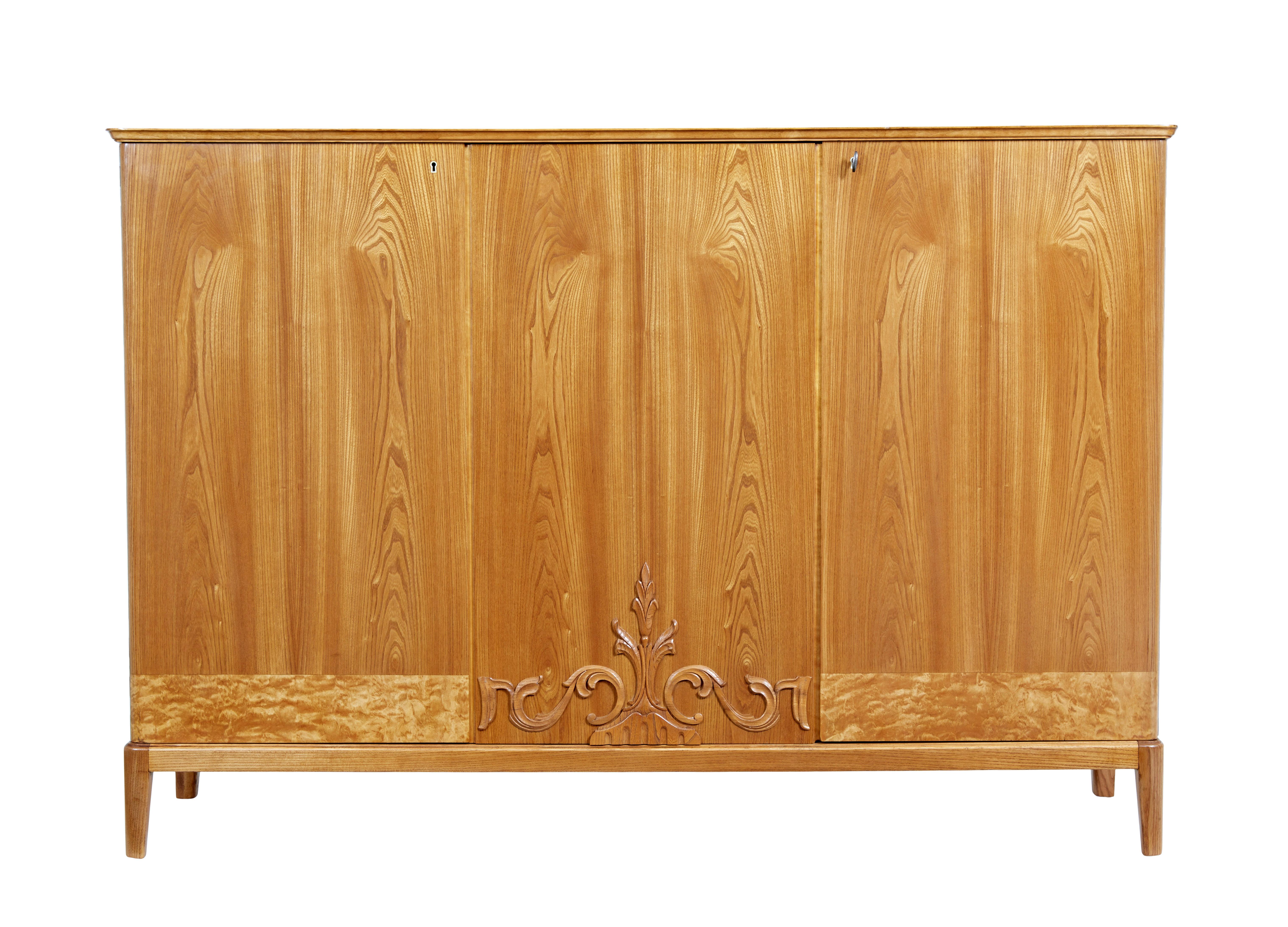 Mid 20th century Fine quality Scandinavian elm sideboard in the art deco taste.  Providing double door and single door storage space.  Double doors open to reveal 2 shelves either side of a central partition.  3 fitted drawer slides and a further