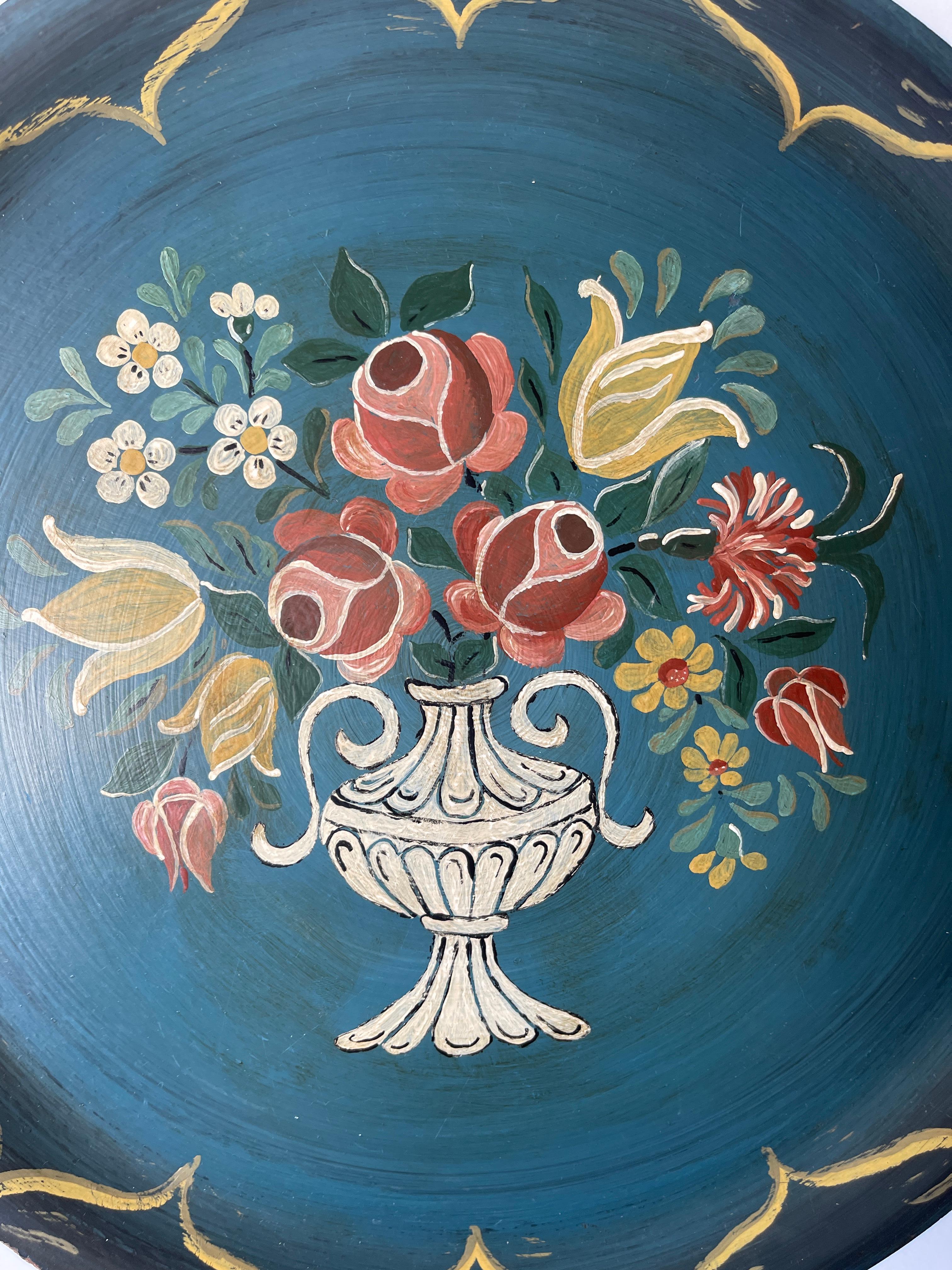 Merveilleux plateau circulaire en teck de l'art populaire suédois avec un bouquet floral peint à la main dans un motif d'urne sur la partie supérieure. Teck à ruban naturel sur la face inférieure.