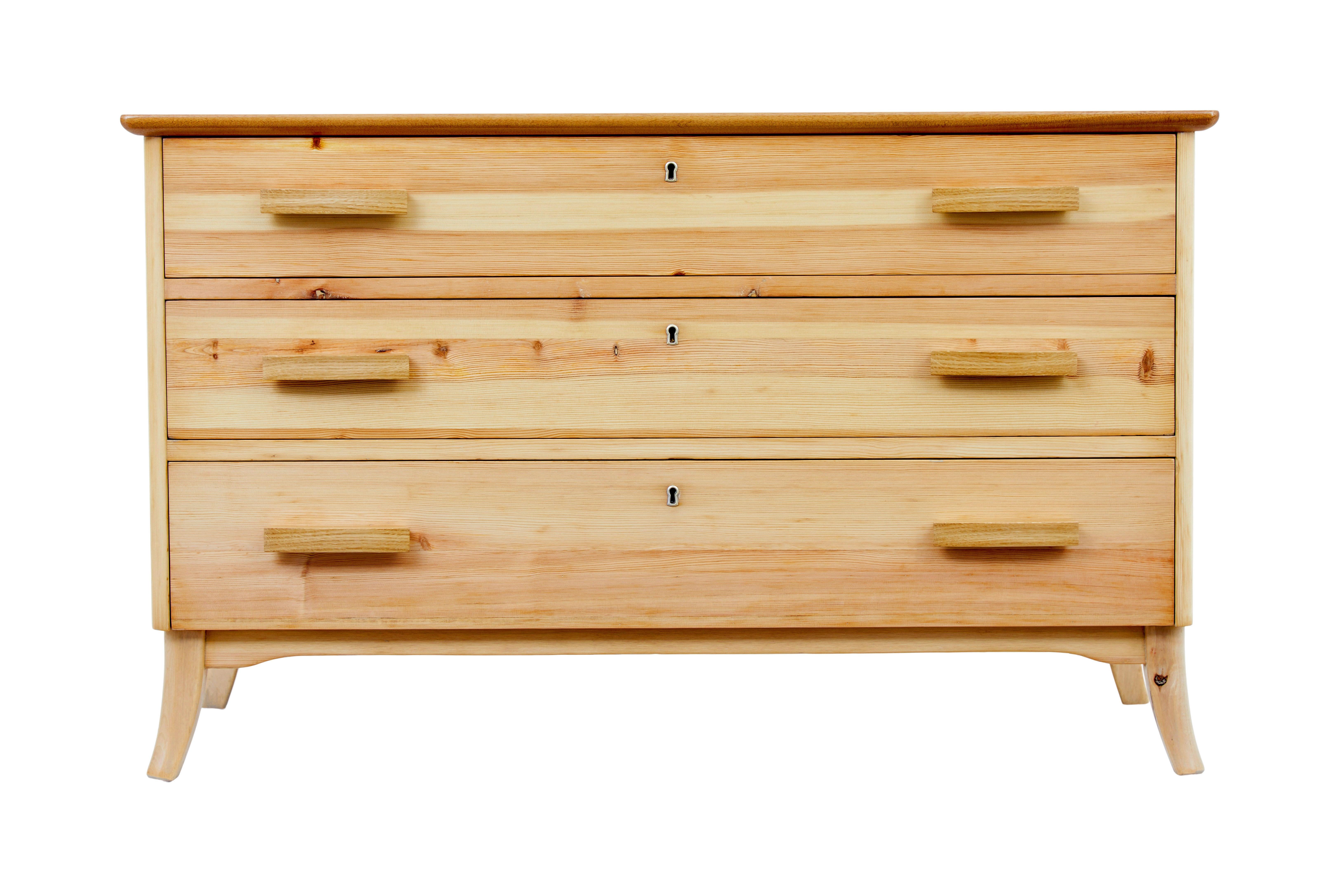 Commode en pin suédois du milieu du 20e siècle, vers 1960.

Commode inhabituelle du milieu du siècle dernier, qui met en valeur le grain et la couleur du pin plutôt que d'essayer de les dissimuler.  Ce modèle aurait normalement été recouvert de