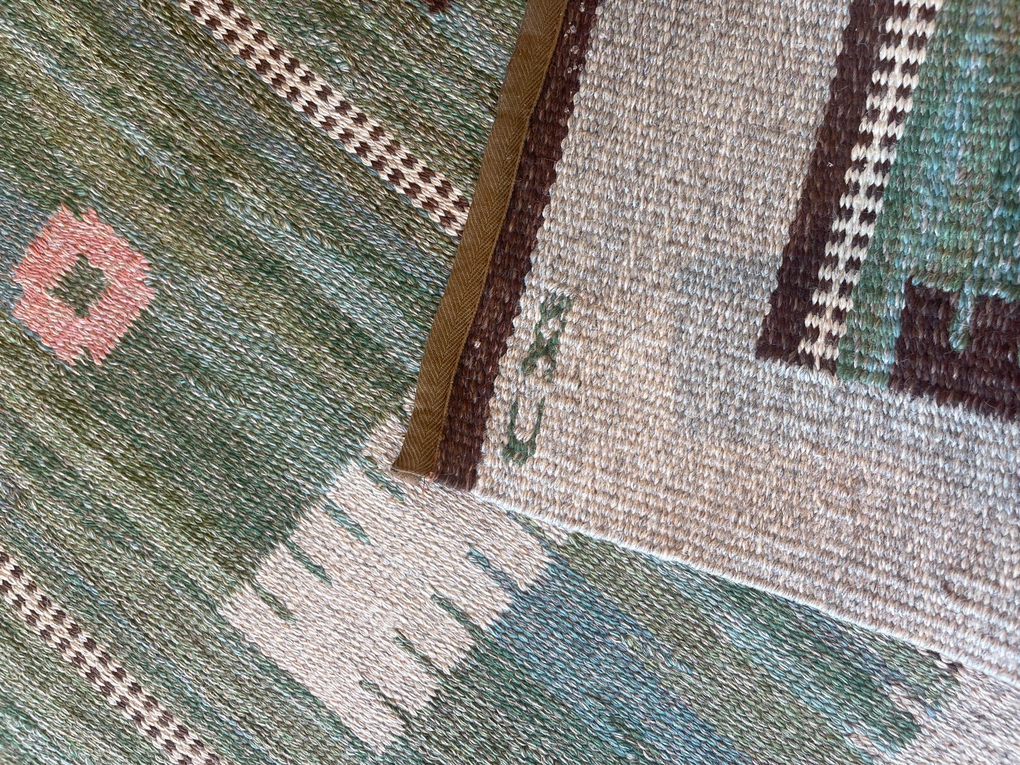 This vintage handwoven Swedish rug has a shaded refined sage green field with scattered varied geometric pendants and lozenges, in a plain ivory border. Signed CD by the original artist, Carl Dangel.

One of the few men working in the field during