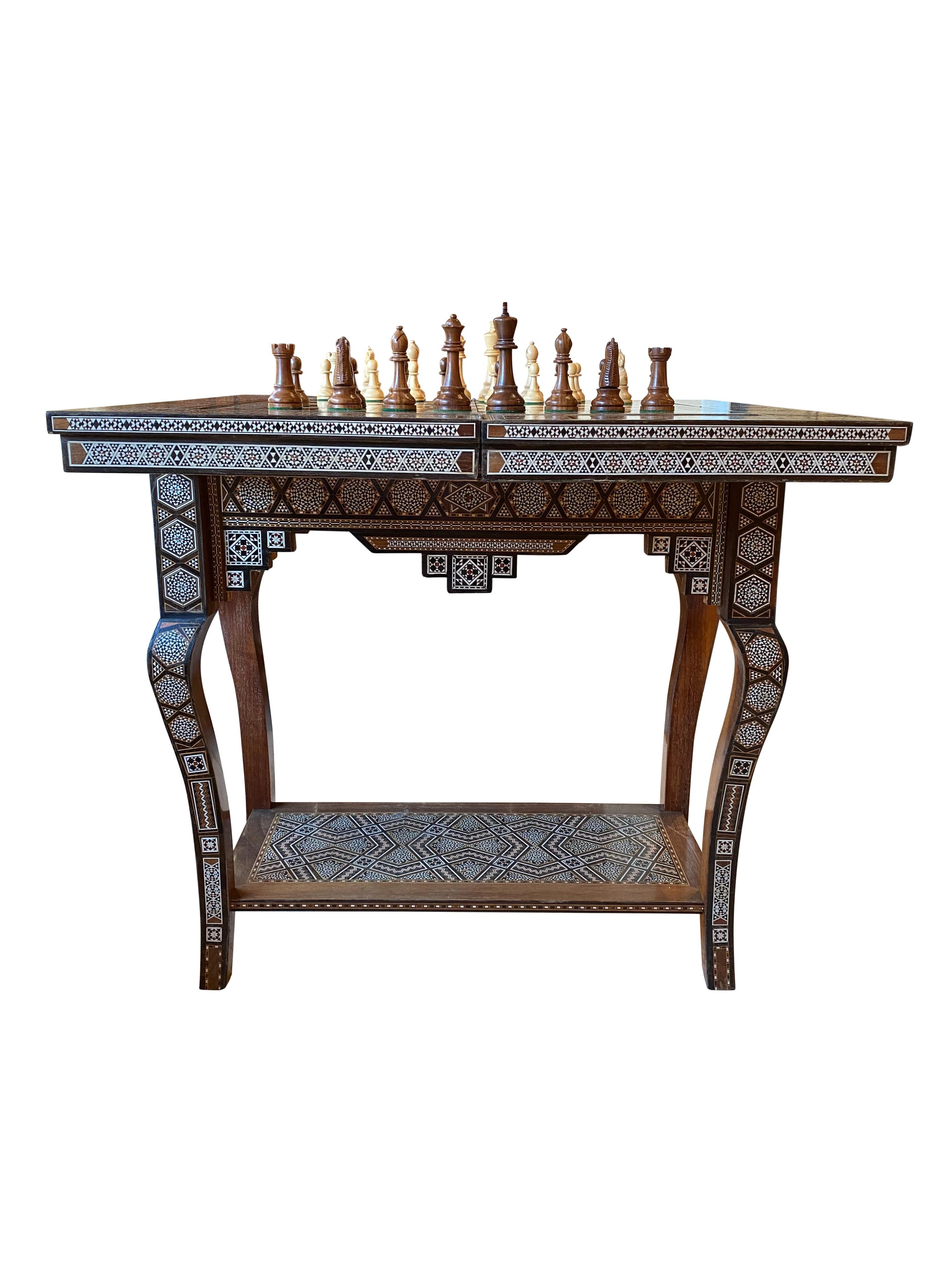 This profusely inlaid Syrian Damascus games table dates from circa 1910, and has multiple geometric and asymmetric inlays of various woods and mother of pearl.

The hinged lid opens to reveal a similarly inlaid interior and a removable reversible
