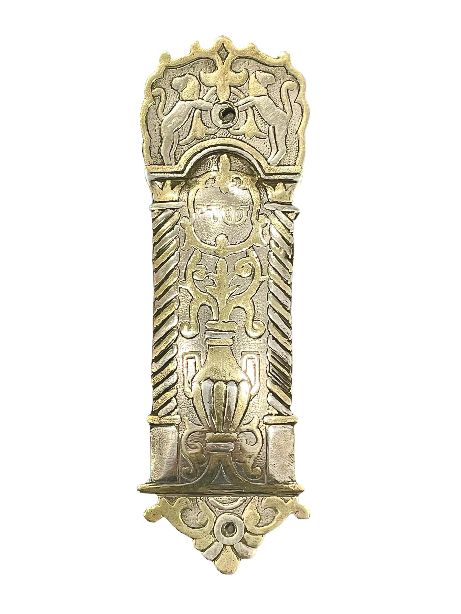 Handmade silver and gold mezuzah case. Made in a Damascened technique, the case is inlaid with silver and gold, to create a beautiful, primitively crafted piece. At the top, a pair of lions surrounded by floral motives come together, holding the