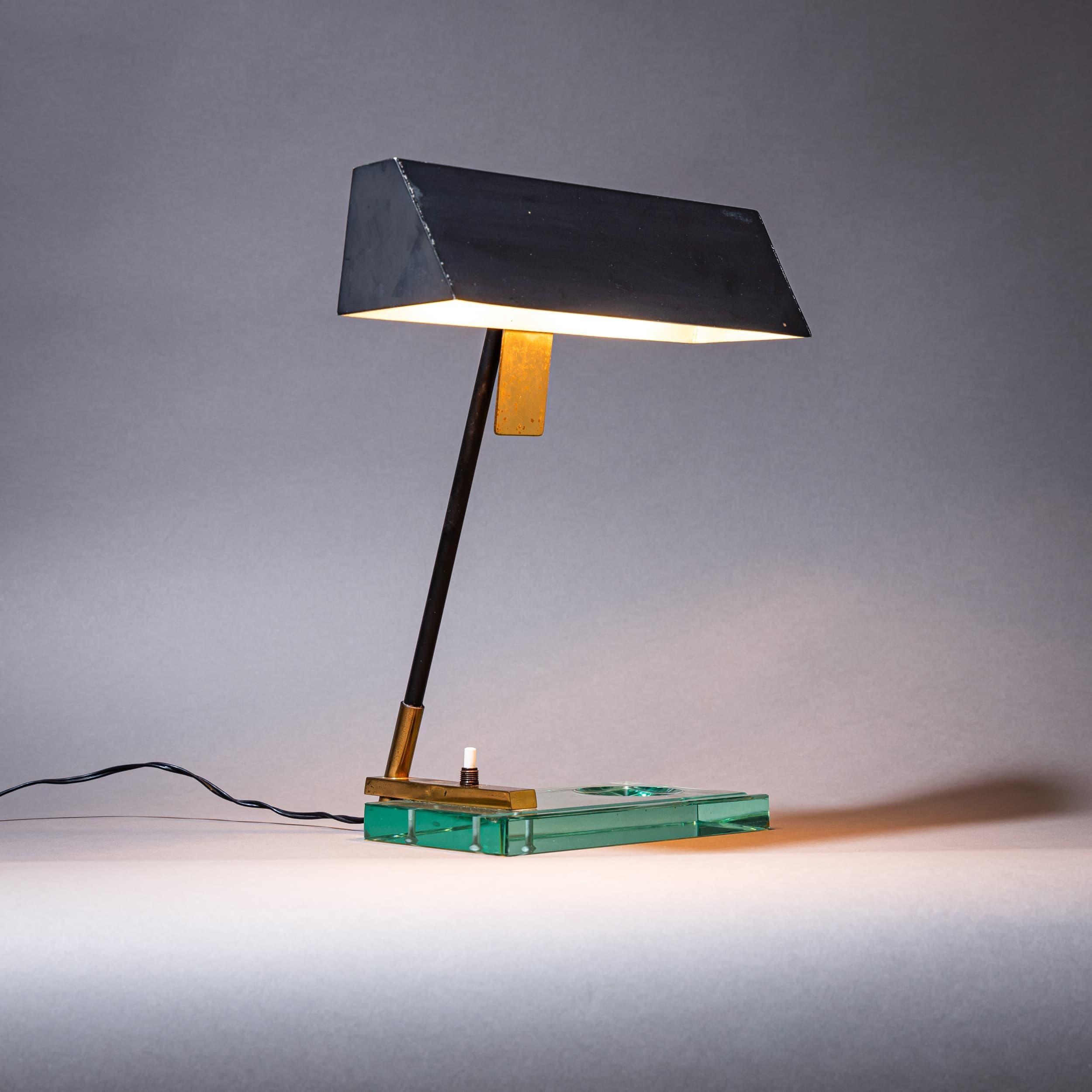 Lámpara de sobremesa de cristal y latón de Fontana Arte, con cenicero lateral y pantalla lacada en negro. Ilustrado en la bibliografía.