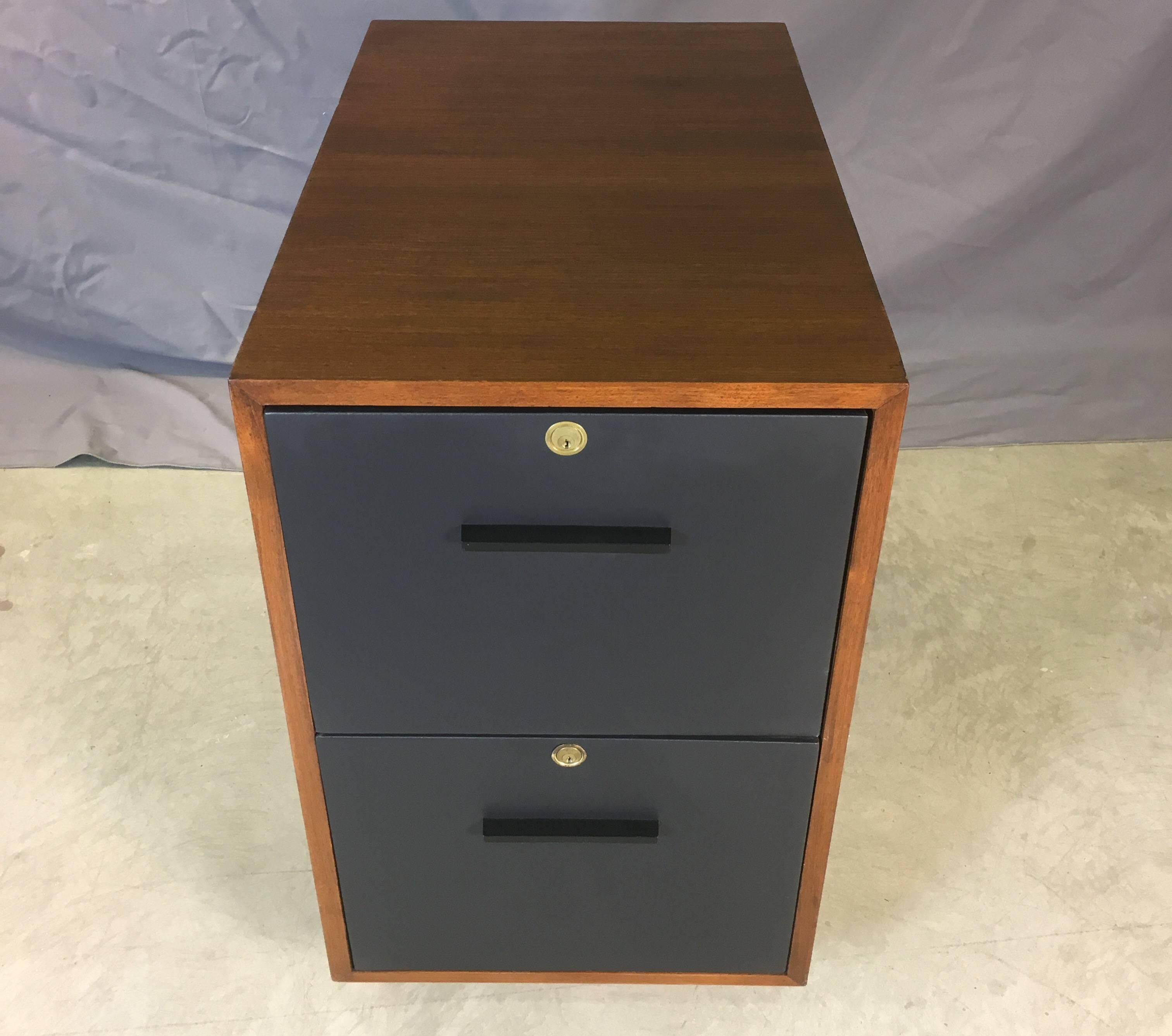 Vintage mid-20th century teak wood and leather front rolling file cabinet. The cabinet has two drawers for storage. The drawer fronts are wrapped in leather. Fully restored. Inside drawer holds 15” hanging files. Unmarked.