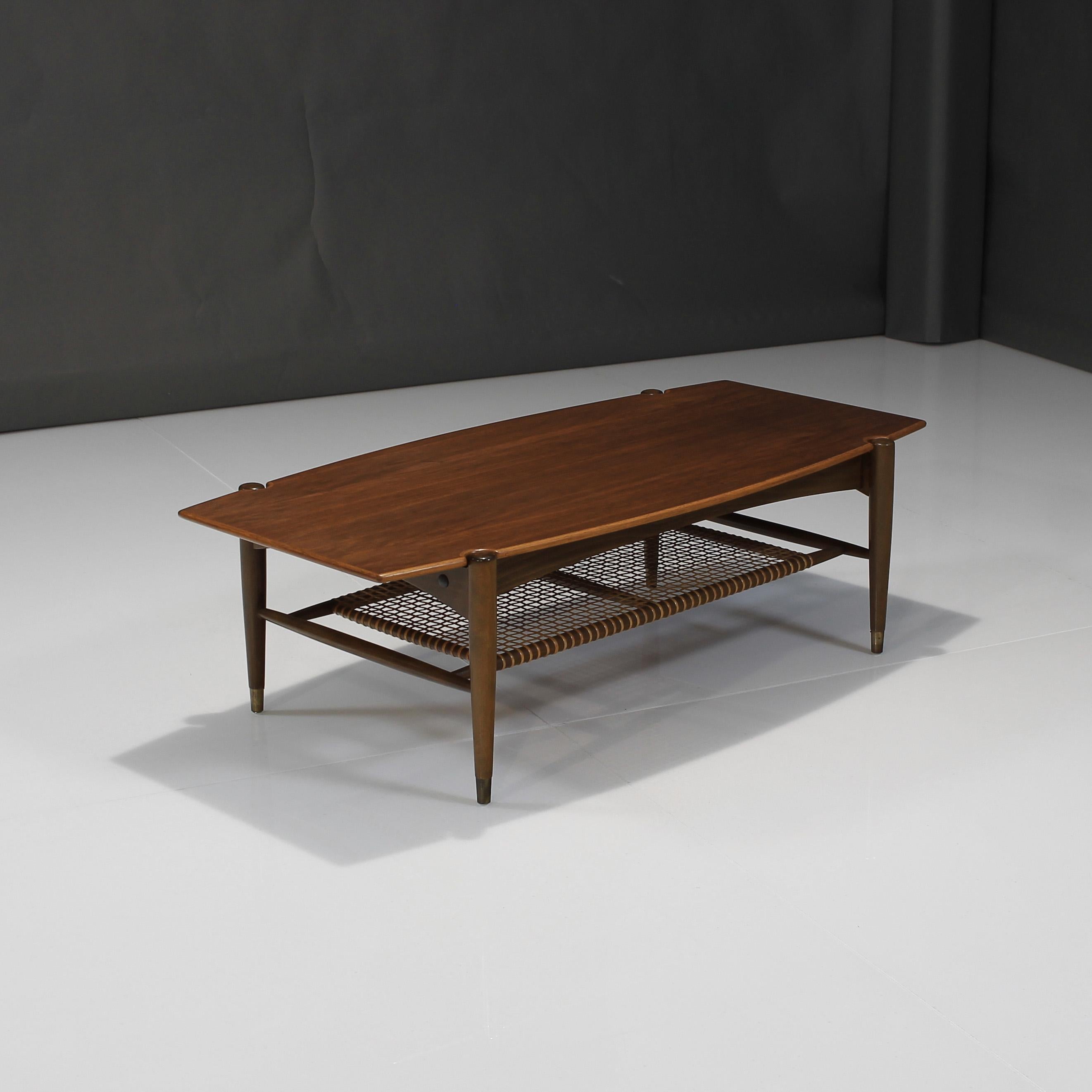 About this Folke Ohlsson coffee table by DUX in teak and cane:

Bring in all of the warmth and character to your living space with this wonderful vintage piece from Sweden. Elevated on tapered legs with aged brass accents and showing off beautiful