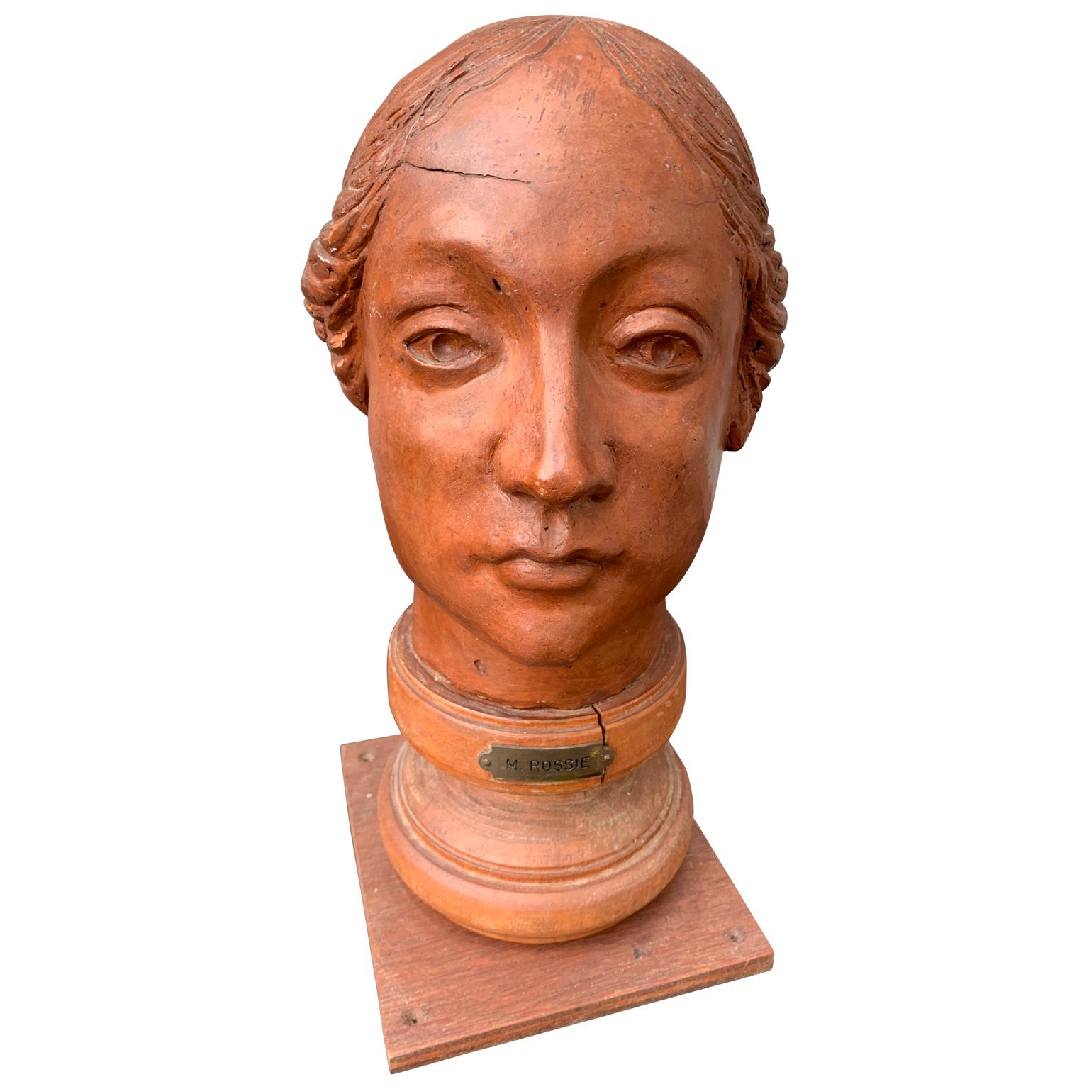 An mid-20th century bust of a woman on a wooden base. Signed with on brass sign 