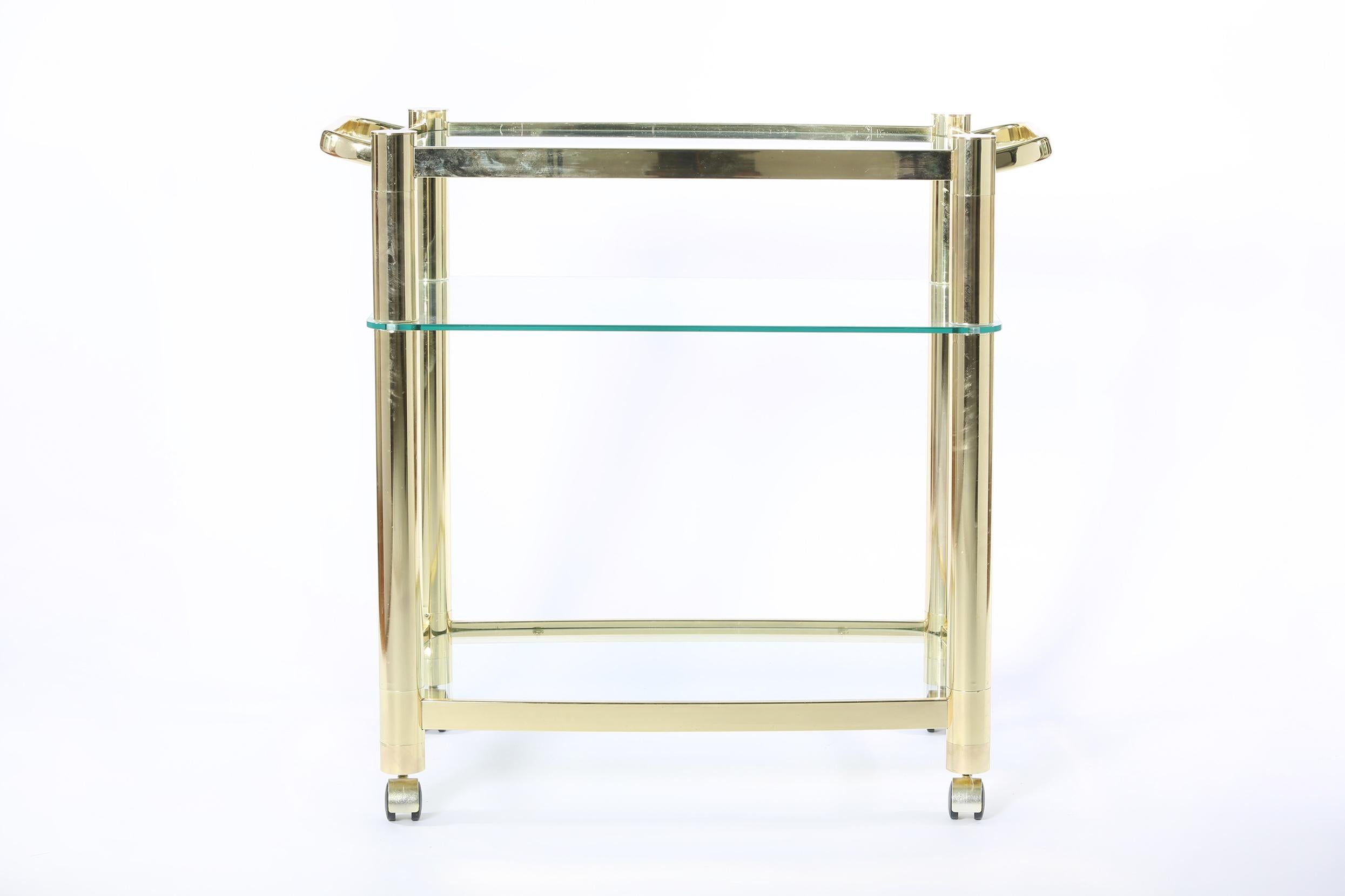 Mid-20th century three glass shelves wheeled bar cart / tea trolly with side handles. The bar cart is in great vintage condition. Minor wear consistent with age / use. The cart stand about 33 inches high x 37 inches length x 19 inches wide.
