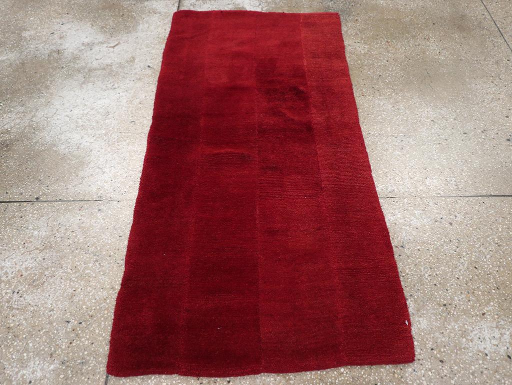 Une pile de laine avec des nœuds tibétains sur une base de coton. Il s'agit d'une dispersion monochrome rouge à quatre sections. Les rouges sont subtilement différents et la couture d'assemblage est visible, ce qui évite la platitude de nombreuses