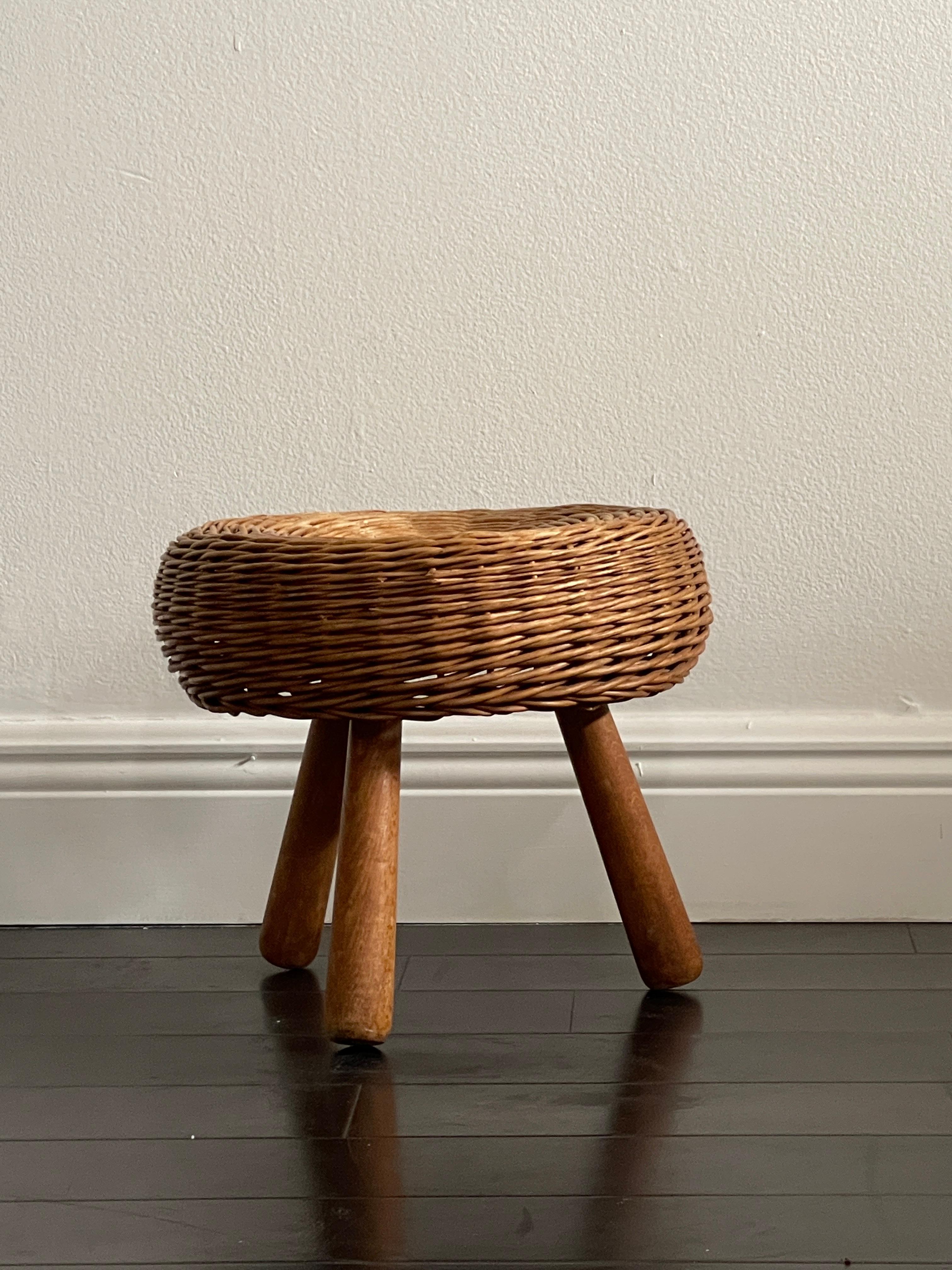 Mid 20th century Tony Paul Wicker stool with three legs and a beautiful handcrafted round top. This iconic stool is very popular and fits in almost any room or space. The stool is in great vintage condition and ready to make a statement in your