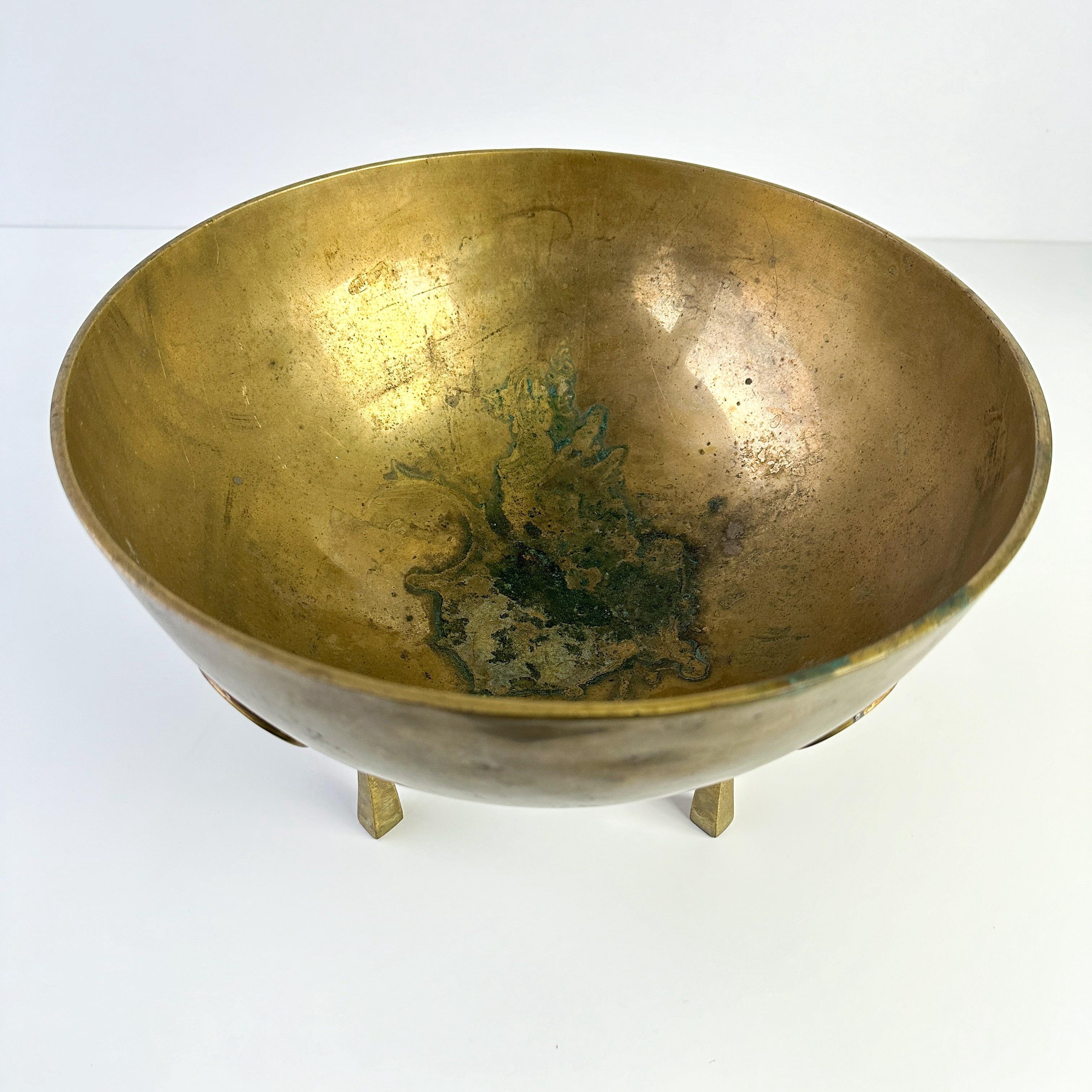 Vintage mid 20th century transitional solid brass footed bowl. Large and heavy concave brass bowl with sculptural set of four elevated feet. Perfect addition to bookshelf, table etc and can be filled with matchbook collection, crystals, etc.