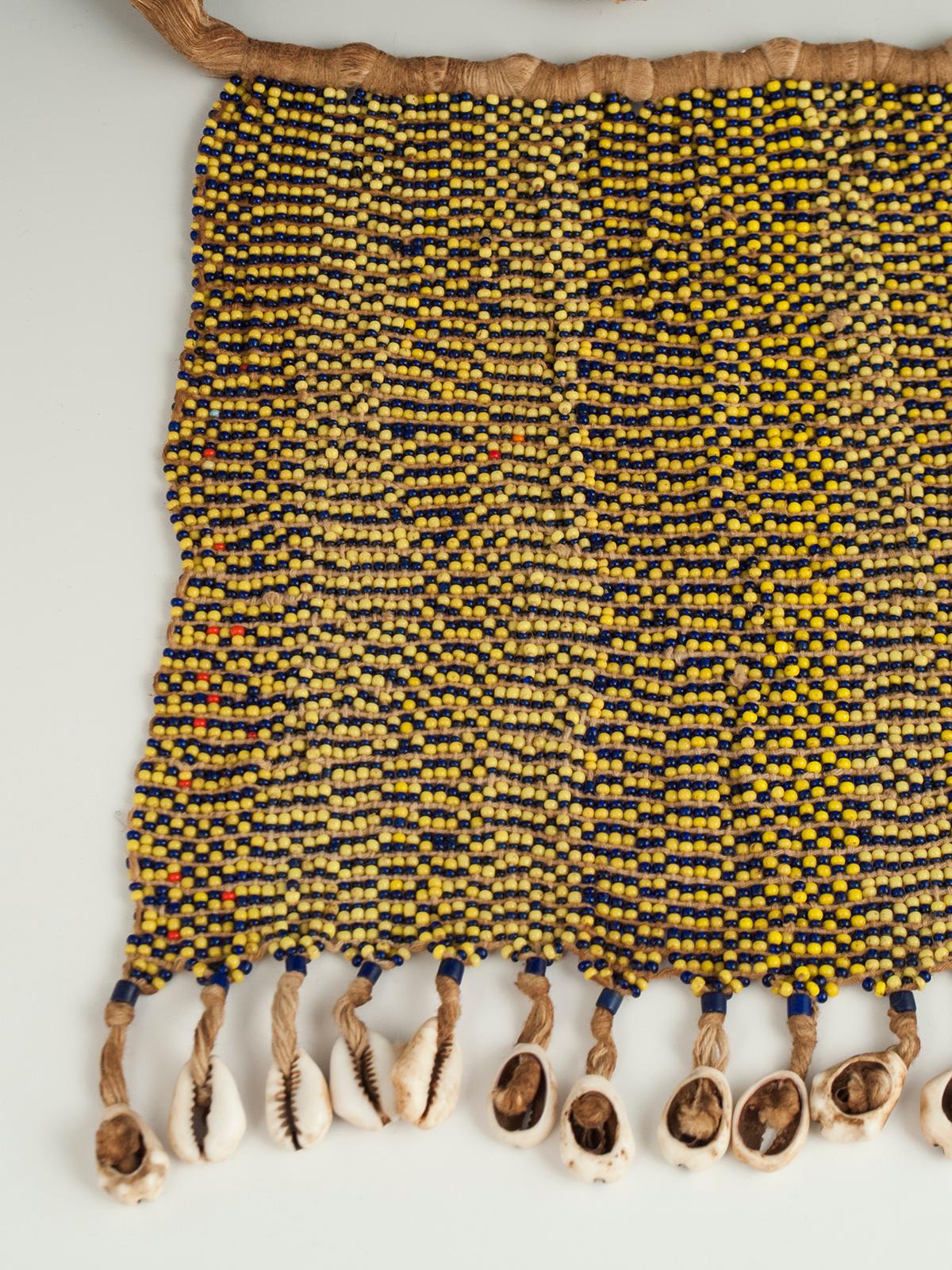 Mid-20th century tribal beaded cache-sexe modesty apron (pikuran), Bana Guili people, Mandara Mountains, Cameroon

An unusual cache-sexe made of blue and yellow beads so scattered that they appear pea green from a distance. These colorful