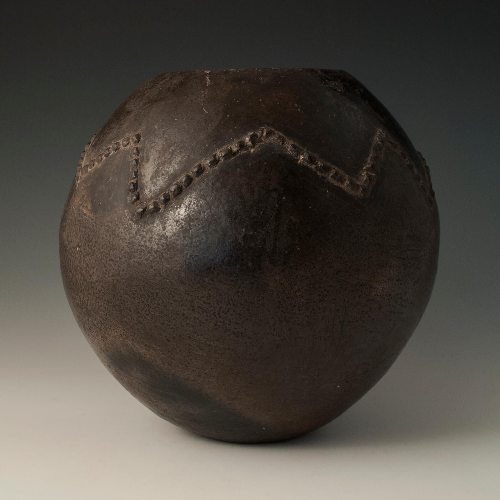 Mid-20th century tribal ceramic beer pot, Zulu People, South Africa.

Made of burnished clay with zigzag amasumpa decoration, this pot (umancishane) was used for drinking sorghum beer. The condition is excellent with one small rim crack. 


  