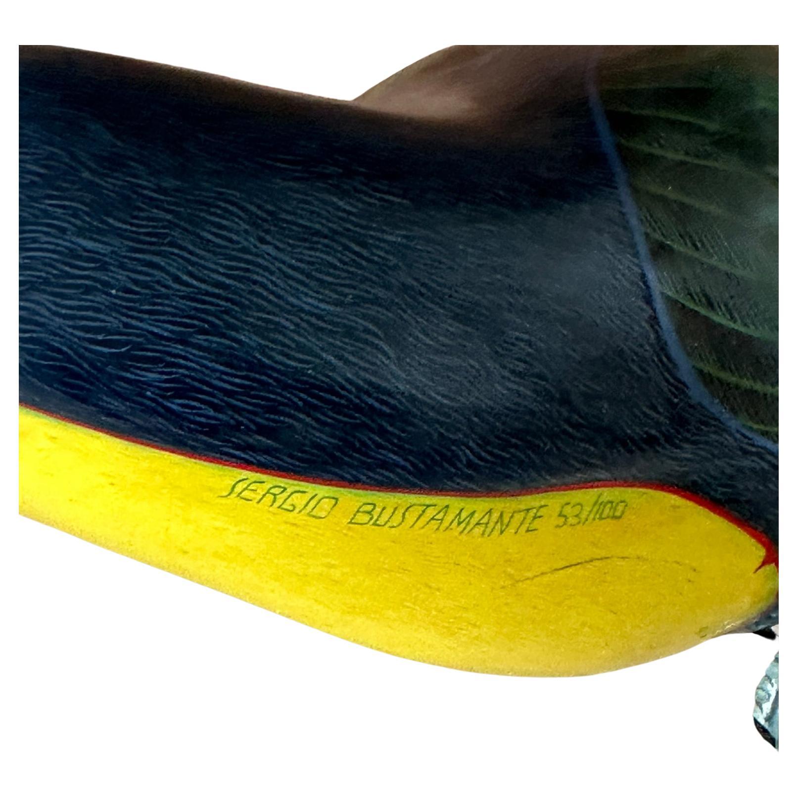 This charming vintage piece features a delicate paper mache toucan crafted by the renowned artist Sergio Bustamante.
Known for his whimsical and imaginative creations, Bustamante's artistry is evident in the intricate details and vibrant colors of