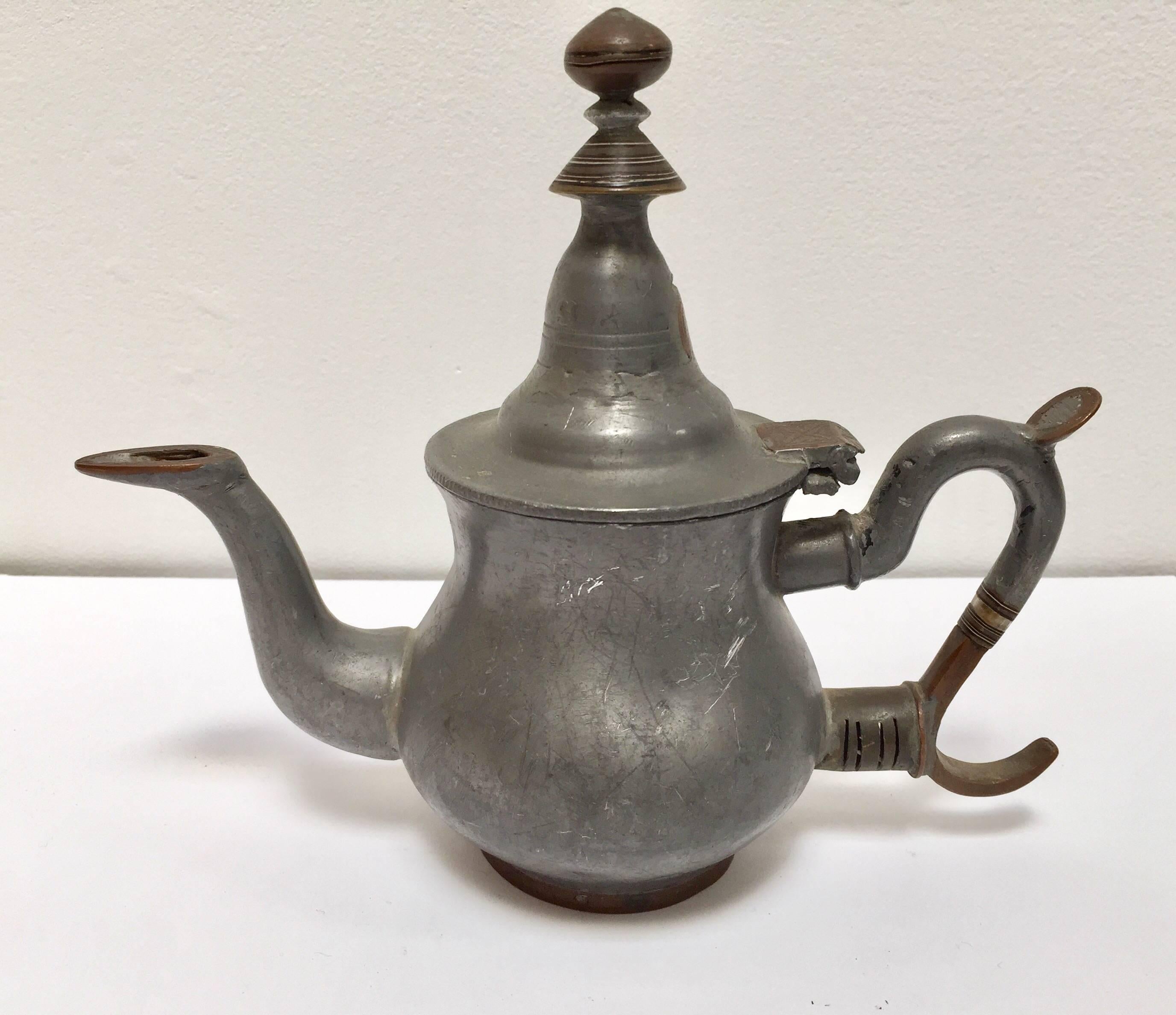 Mid-20th century Tuareg teapot Mauritania, Africa.
Handcrafted of pewter, copper and brass decorations.
The care, attention to detail and goldsmith techniques, used by the Tuareg to create their own jewelry, are also used in everyday objects.
The