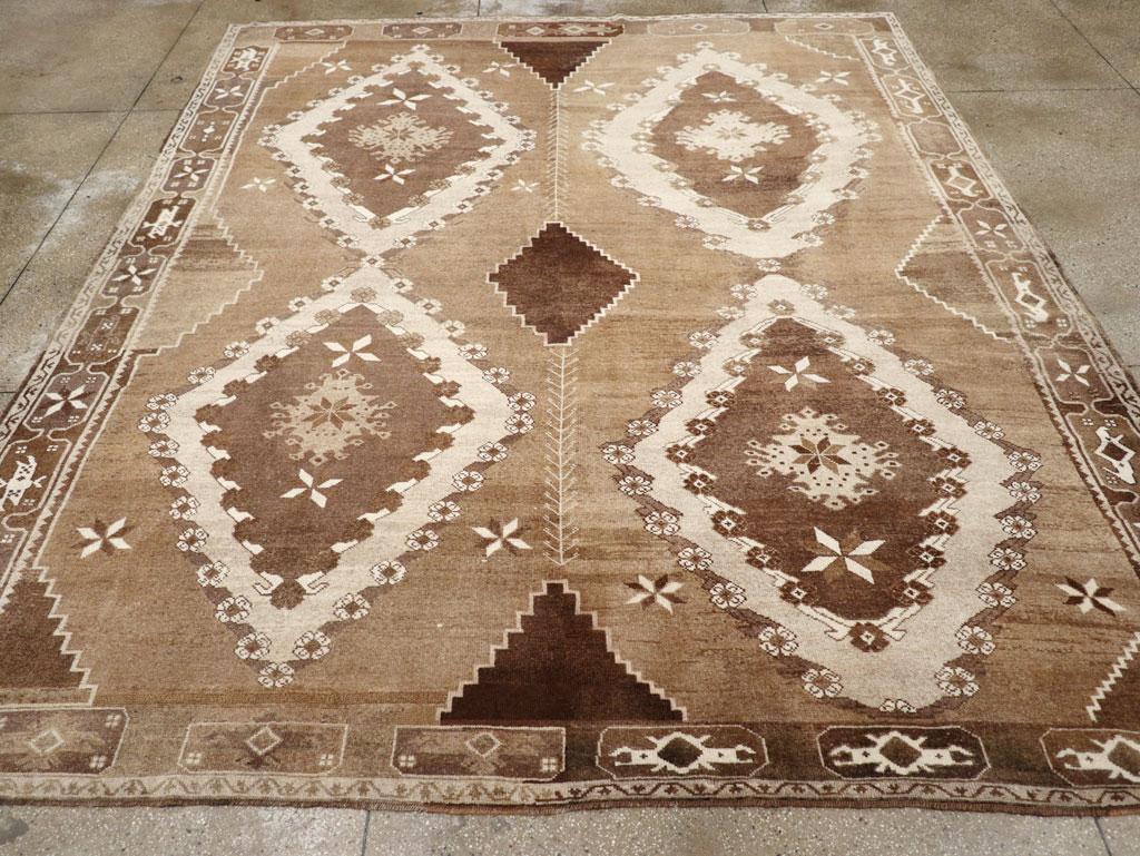 A Wool pile with symmetric knots on a wool foundation. The soft brown field, significantly abrashed, is notched at the sides, top, and bottom in darker browns, with a matching central dark lozenge. Four bold, nested ivory lozenges with