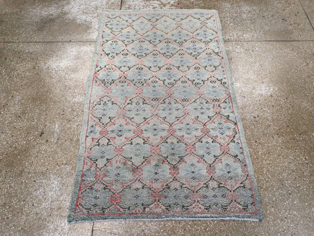 Ein türkisch-anatolischer Teppich im Vintage-Stil. Ein leicht geschwungenes Feldton-Gitter umrahmt eng eine versetzte, halbtropfenförmige Anordnung von elfenbeinfarbenen Vierblättern mit schmalsten Rändern. Die zahlreichen weißen Flecken sind in