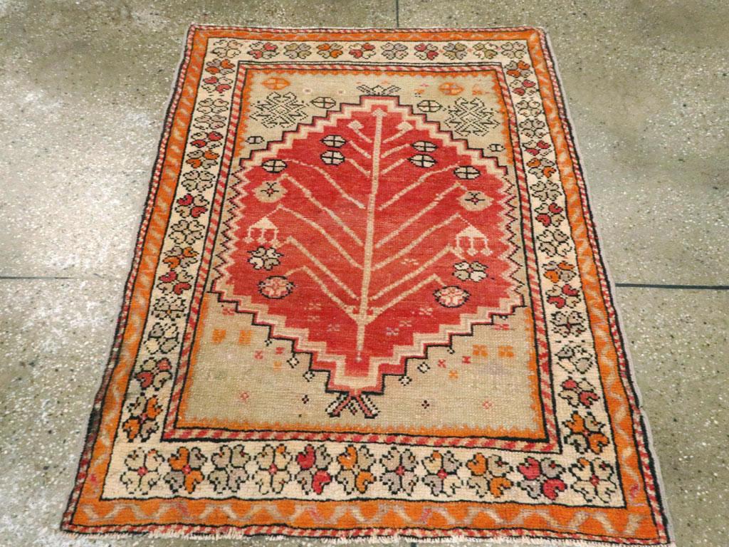 Ein türkisch-anatolischer Teppich im Vintage-Stil. Ein korallenrotes Feld aus der Region Bergama im Nordwesten der Türkei zeigt eine kräftige Pflanze mit geraden, nach oben gebogenen Stängeln, die in Rosetten oder Schmuckanhängern enden. Die