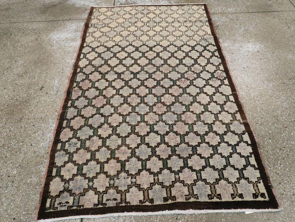 A vintage Turkish Anatolian throw rug. Charcoal to beige with a charcoal string border. The field is defined by a stepped cartouche-inspired lattice enclosing eight petal flowers (or stars).

Hand-knotted in Turkey
Wool
One-of-a-kind

Measures: 3'