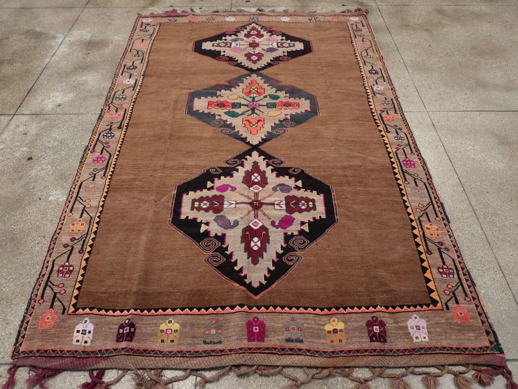 Wool pile with symmetric knots on a wool foundation. The rose-brown open field features a single column of three oversized, charcoal rough diamonds, each uniformly enclosing ragged sub-medallions adorned with palmette cruciforms. The green main