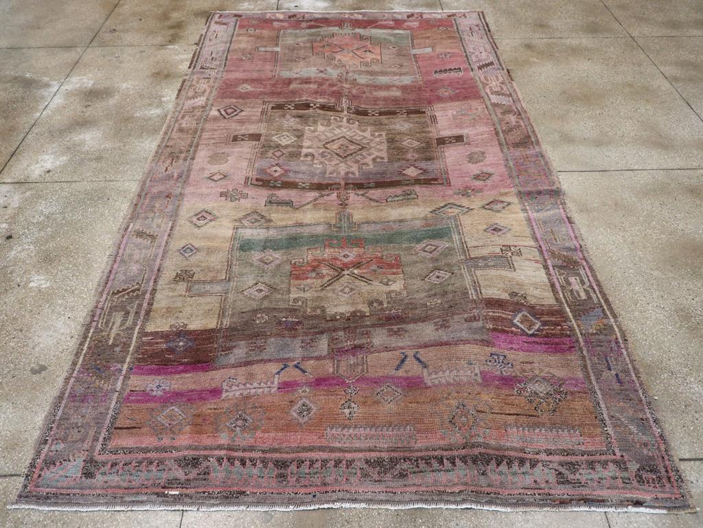 Un mucchio di lana con nodi simmetrici su una base prevalentemente di cotone e un po' di lana. Questo pezzo dalle tonalità tenui mostra le sue origini caucasiche con un medaglione a palo composto da tre quadrati, contro un campo selvaggiamente