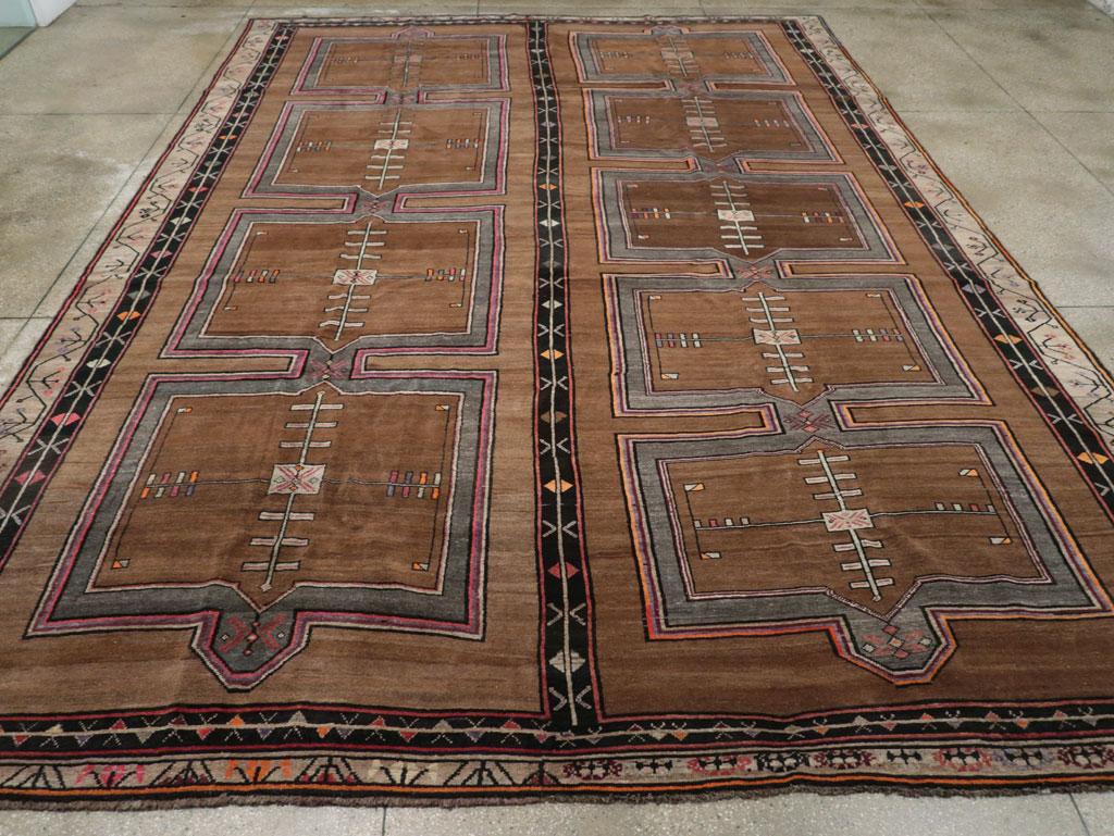 A wool pile of symmetric knots on a wool foundation. This exceptionally large geometric Kars carpet features two columns of four or five connected, abrashed red squares on a red-brown field. The design is highlighted with details in teal green,