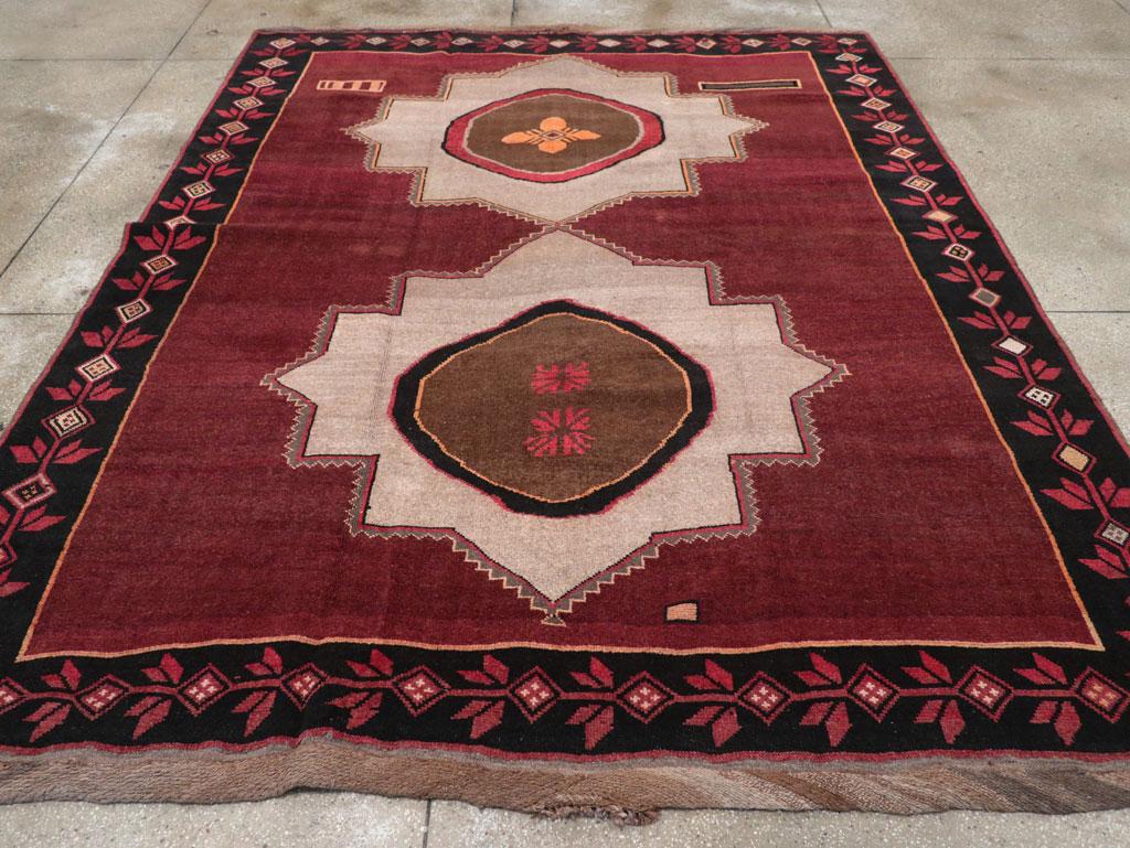 Questo tappeto in velluto di lana, tessuto con nodi simmetrici su una base di lana, ha una forma quasi quadrata. È caratterizzato da due suggestivi medaglioni di sabbia a 12 punte su un campo bordeaux, con motivi interni bordeaux abbinati. Due