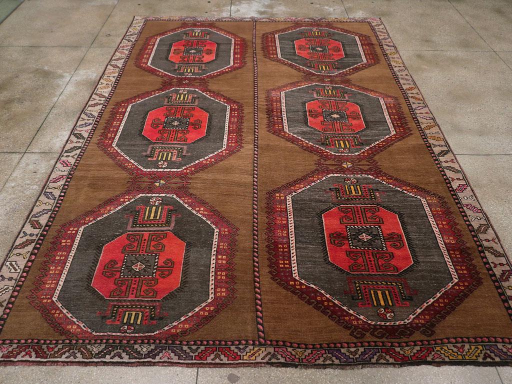 Nœuds symétriques en laine sur une base en laine. Le champ brun présente deux colonnes de trois grands octogones gris ardoise accolés, chacun entourant uniformément un octogone rouge plus petit et des paires de palmettes géométriques stylisées.