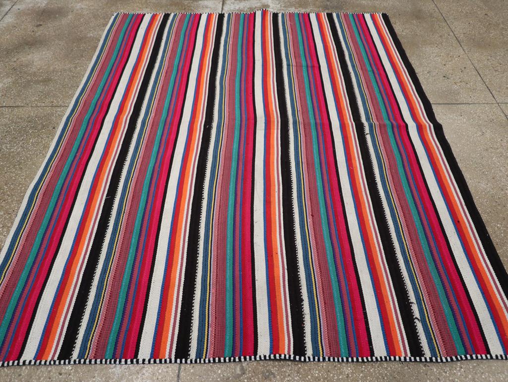 This Mid-20th century Turkish Flatweave Kilim rug, measuring 5' 11