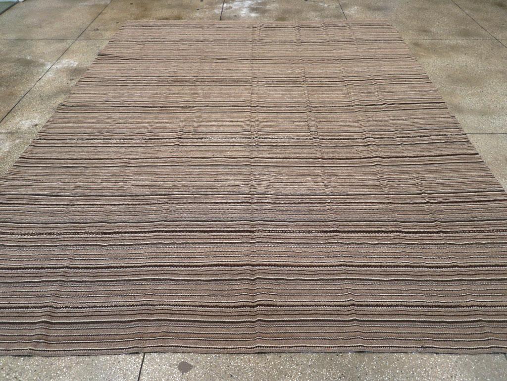 This Mid-20th century Turkish Flatweave Kilim rug, measuring 9' 10