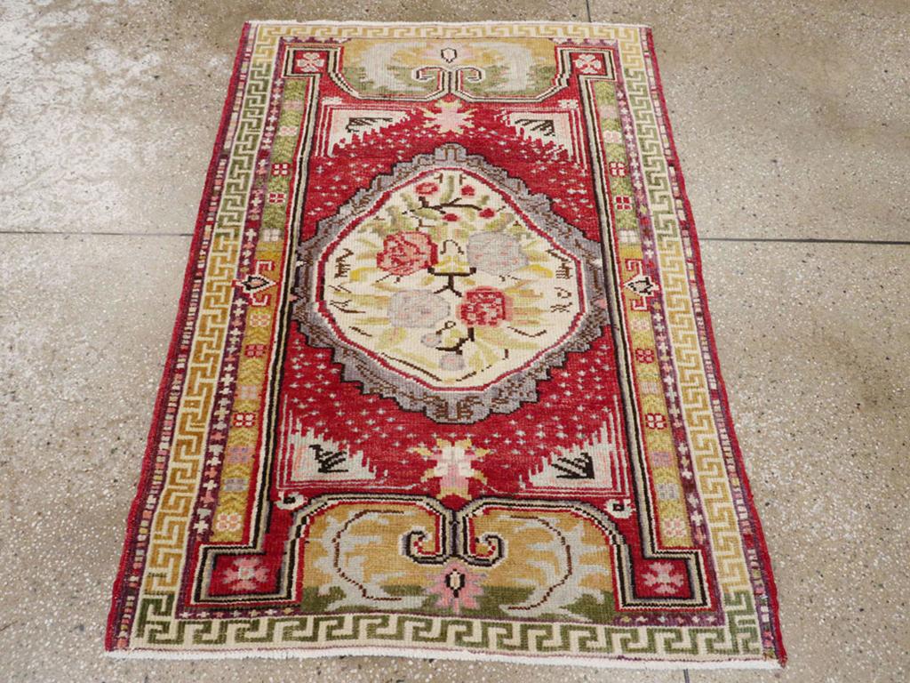 Ein alter türkischer Ghiordes-Teppich. Ein schiefes, ovales Medaillon aus altem Elfenbein enthält vier Rosen und einen Stiel auf rotem Grund mit dreieckigen Eckstücken aus Elfenbein. Der Effekt ist vage neoklassisch mit dem Zusatz der griechischen