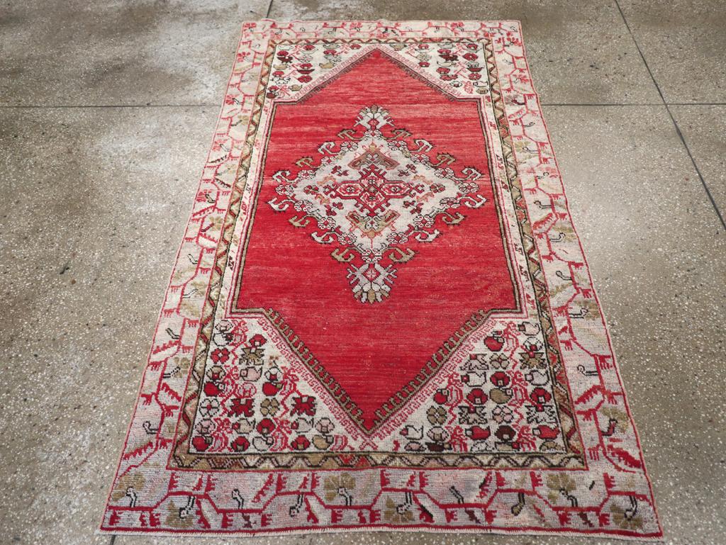 Tapis d'accent Oushak turc vintage. Ce plat turc est composé d'un champ ouvert brun panaché présentant un médaillon de diamants pendants avec une rosette et une bordure de fleurs AT&T. Les écoinçons ivoire sont remplis de fleurs délicates et la