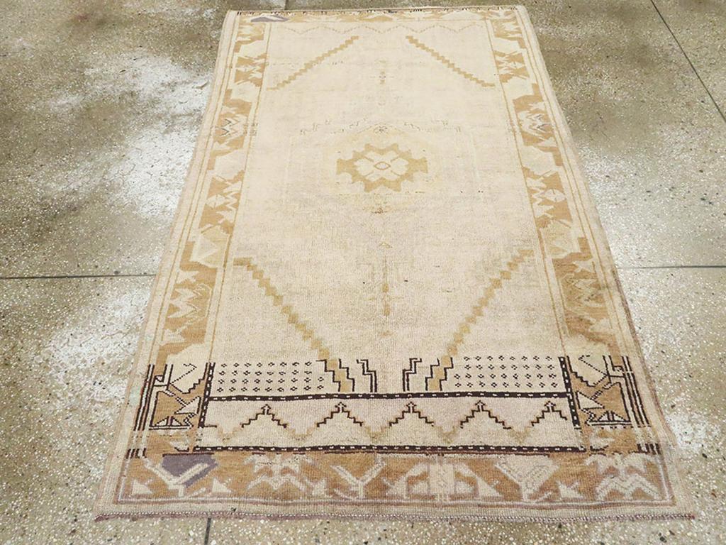 Tapis d'accent Oushak turc vintage. Ce parterre anatolien beige et rouille à champs ouverts présente un aspect Art déco dans ses motifs dépouillés et sa bordure au pochoir. Le médaillon ashik s'intègre bien dans le champ propre.  Une pièce élégante