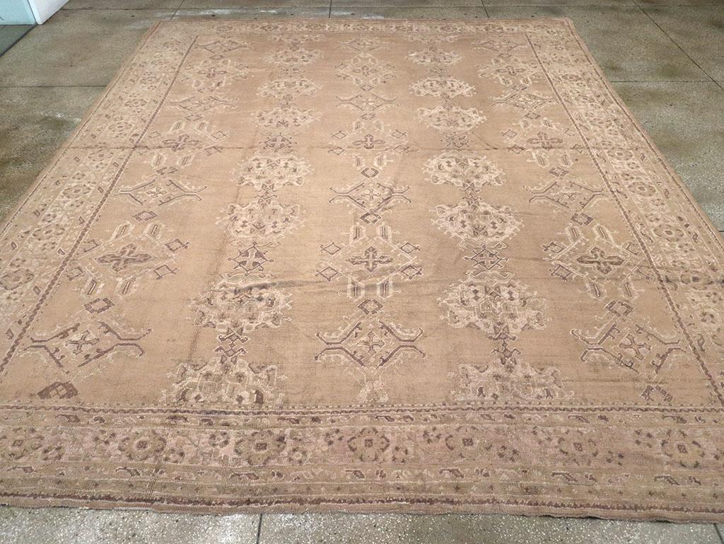 Ein weicher Braunton auf klarem Grund trägt fünf Säulen mit den ikonischen Harshang-Palmetten im Oushak-Stil und kunstvollen Rautenornamenten. Die elfenbeinfarbene Hauptbordüre ist mit Rosetten und türkischen Hyazinthen bestückt.

Handgeknüpft in