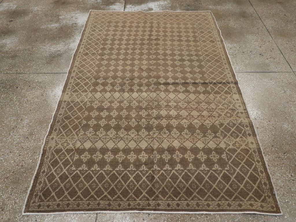 Un tapis d'accent Sivas turc vintage. Le champ et la bordure abrasés présentent un petit motif de diamant répétitif avec des fleurs quadrilobées dans des tons ivoire, brun foncé et paille. Les couleurs changent pour la bordure de cette ville de