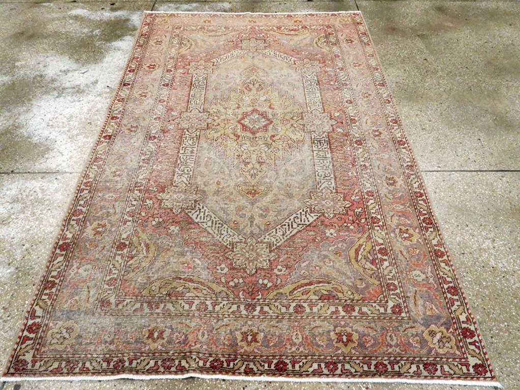 A vintage Turkish Sivas Distressed rug. A hexagonal ivory band of pseudo-calligraphy is anchored by eight octogramme stars and surrounds a light yellow panel. The encompassing grey field features half ovals in the corners. The graphite border of