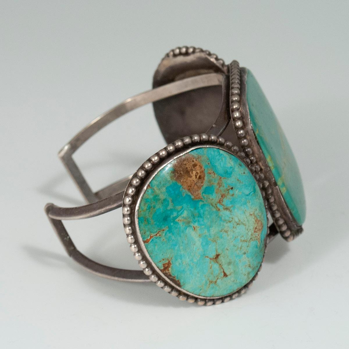 Mid-20th Century Turquoise Snake-Eye cuff bracelet by a Zuni Jeweler

A striking vintage Navajo turquoise cuff with three large cabochons set in silver bezels encircled by fine dots; it bears no markings or signatures. The interior circumference