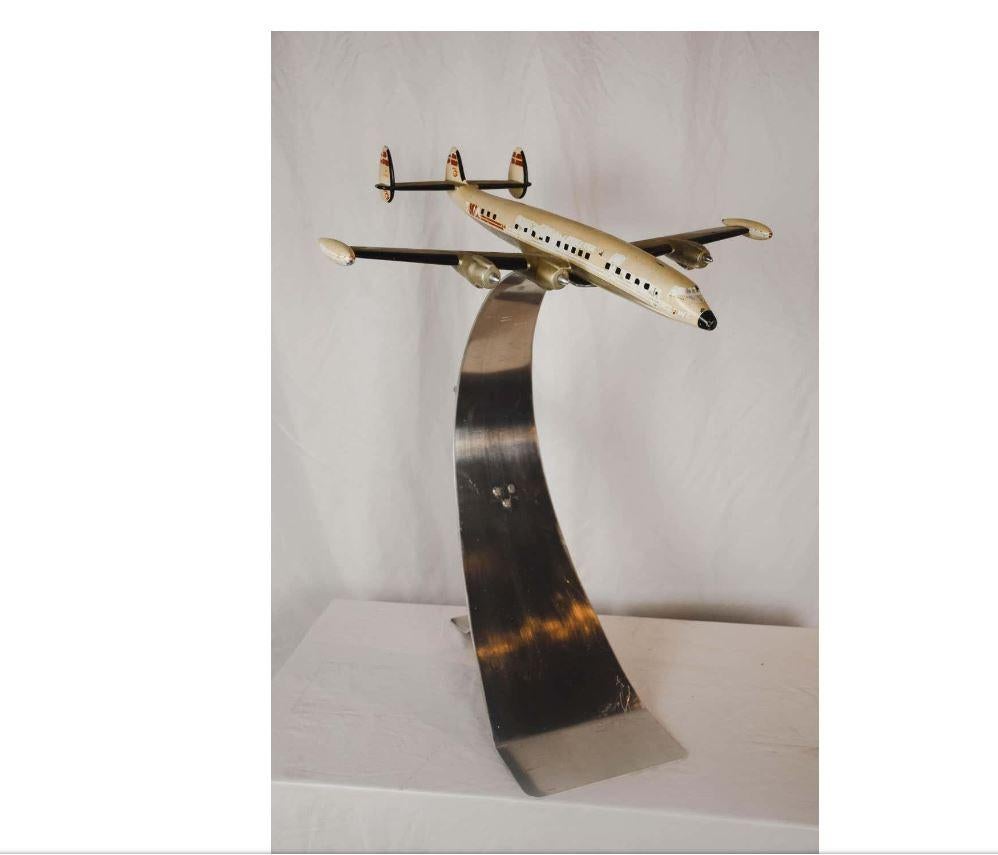 This vintage TWA (Trans World Airlines) airplane model rest on a semi flexible chrome stand. The plane itself is constructed of metal and the style of the chrome base lends itself to the Mid-Century Modern era. This piece will add a touch of the