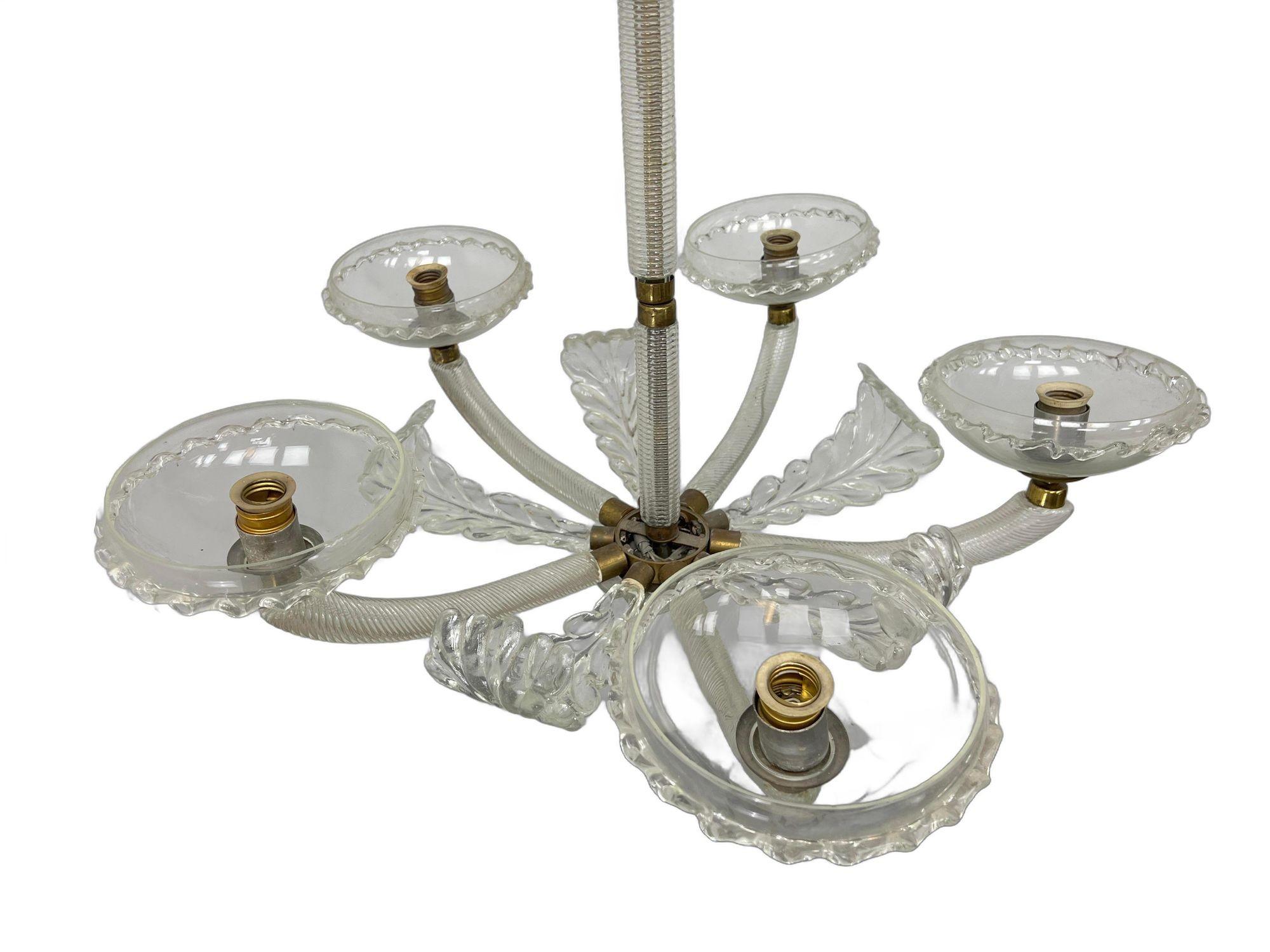 Uno splendido lampadario di Murano della metà del XX secolo in stile Barovier, realizzato con uno squisito vetro artistico soffiato a mano. Questo lampadario a cinque bracci presenta intricati dettagli in vetro trasparente e ottone, tra cui bracci a