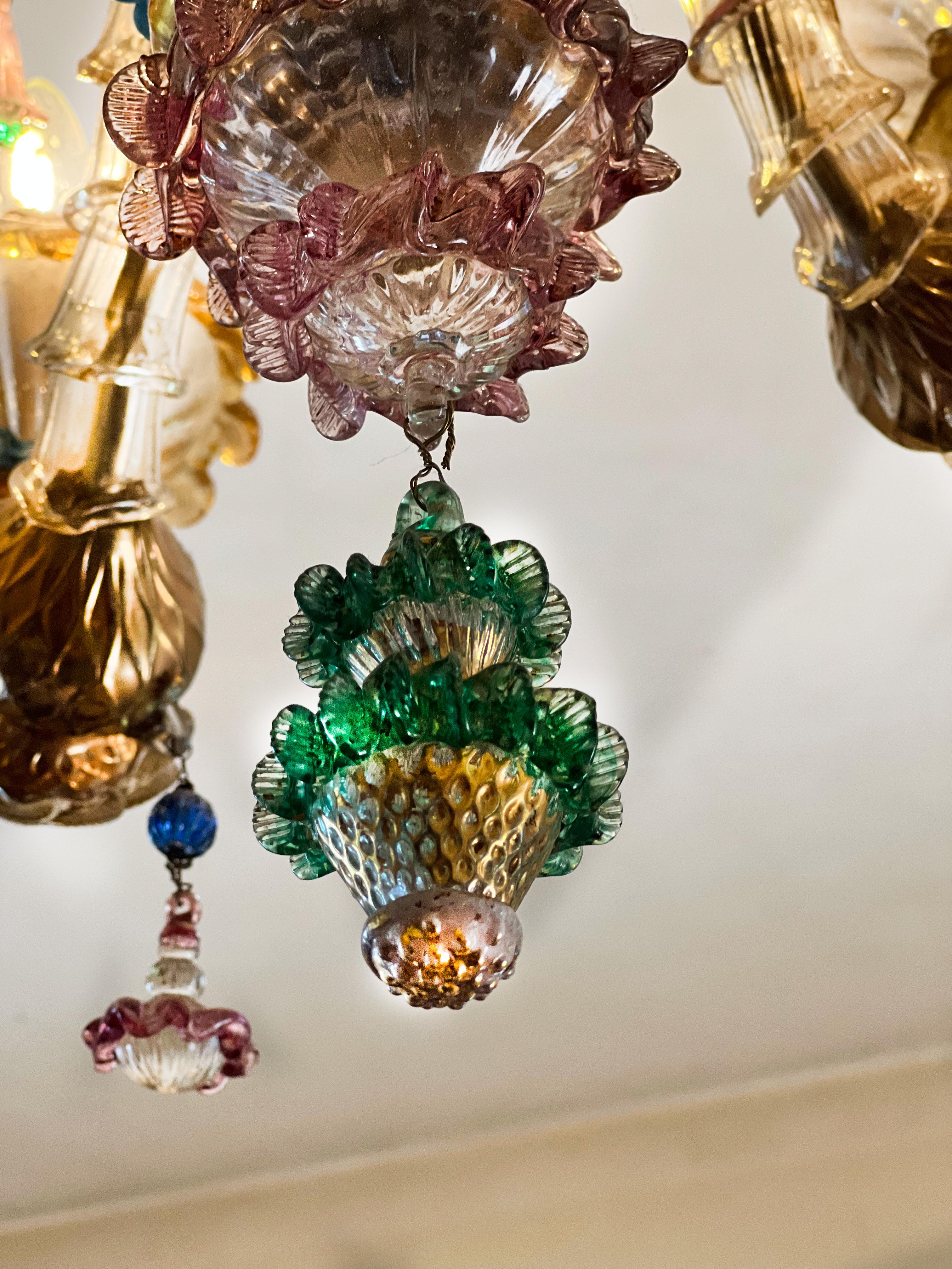 Sumptuous chandelier with 14 flames in very delicate
Murano glass blown crystal color embellished with
24-carat gold applications, principally red and other.
Second half of the 20th century.

Absolute masterpiece of design of the past,