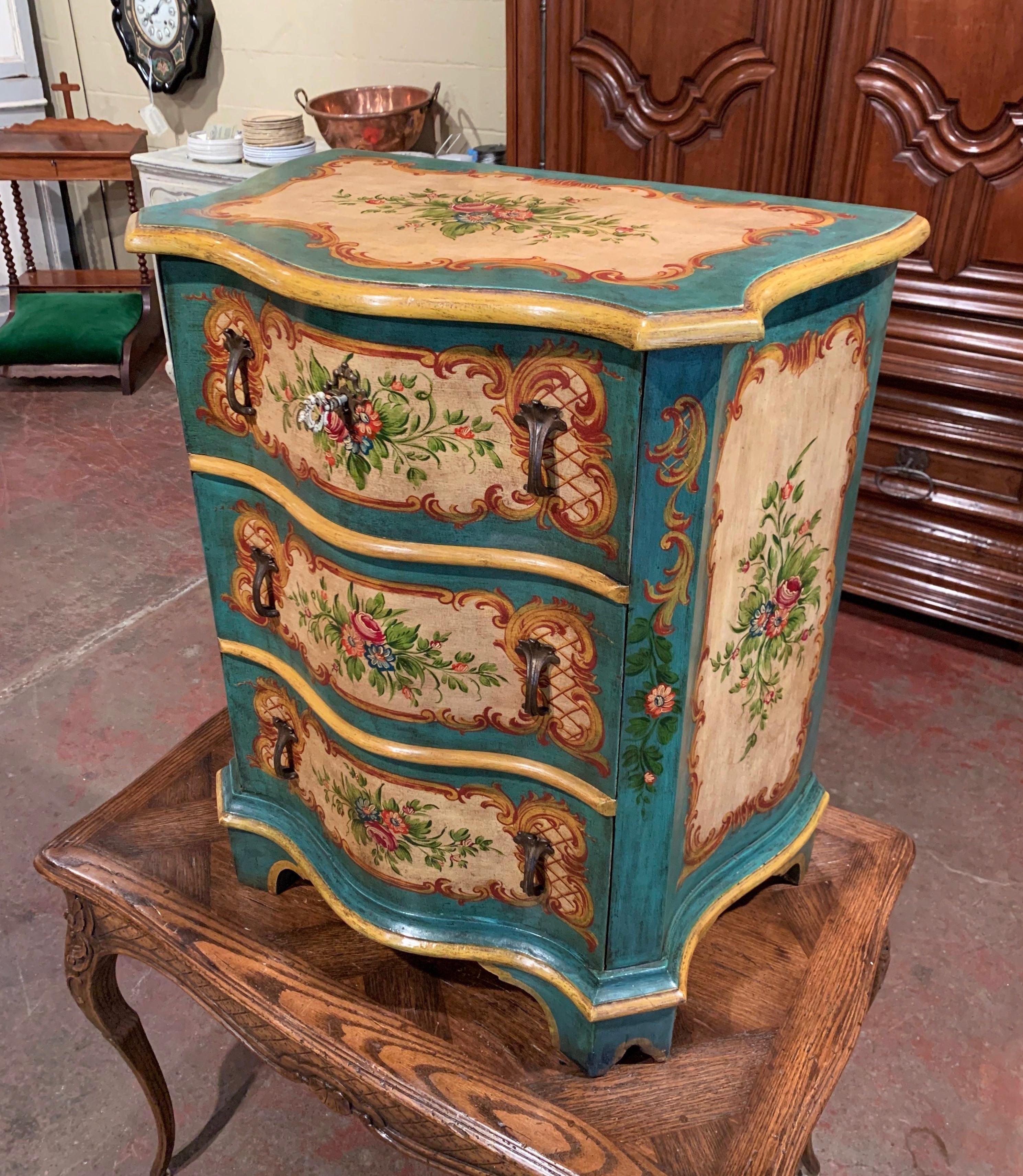 Decorate a bedroom or a living room with this elegant antique commode; crafted in Venice, Italy, circa 1940, the chest stands on bracket feet and features three carved serpentine drawers across the front decorated with metal handles. The colorful
