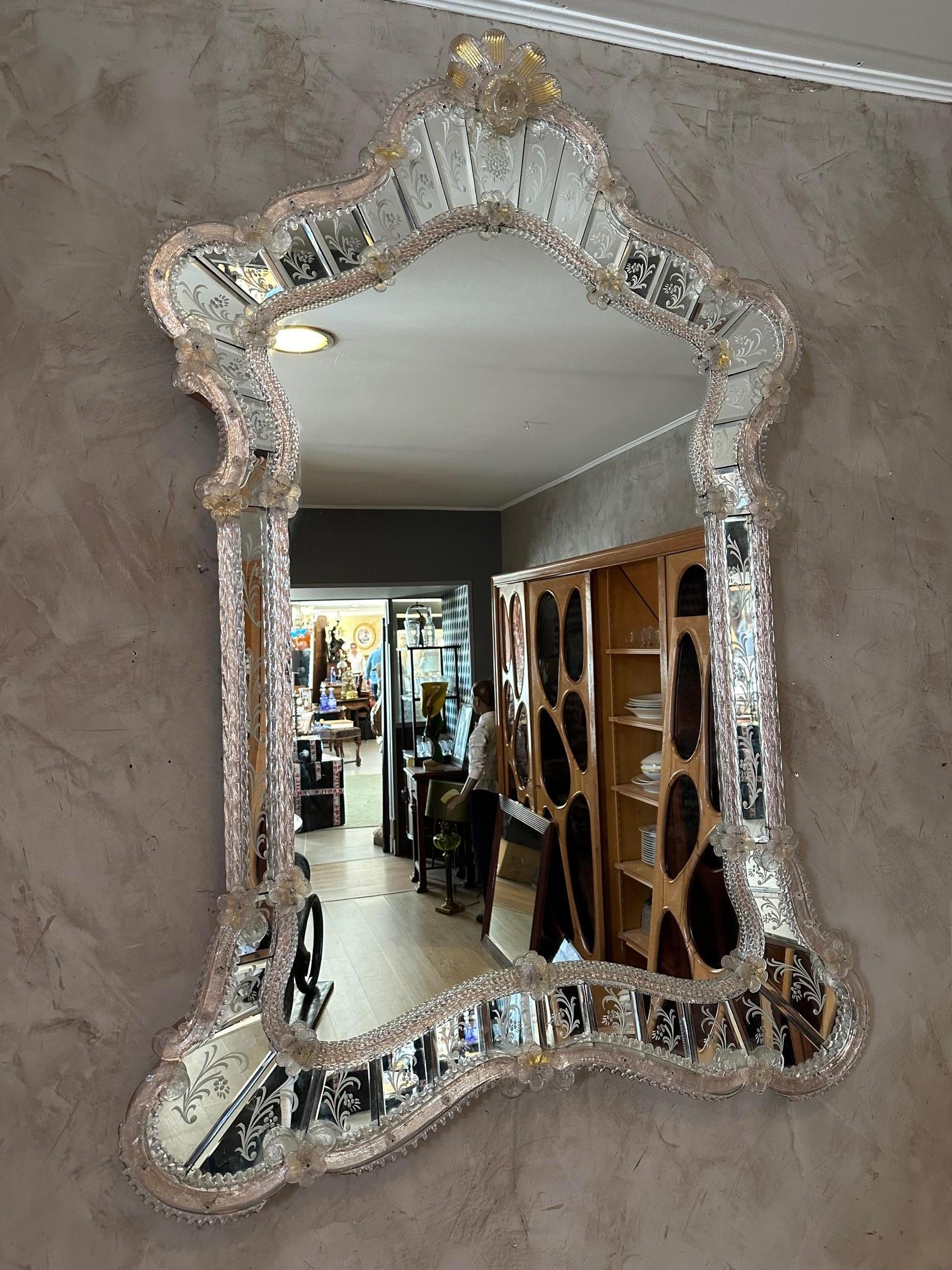 Eccezionale ed elegante specchio veneziano realizzato nella più rigorosa tradizione di Murano con ricche fasce accuratamente incise a mano. 
Il tutto assemblato con elementi in cristallo dorato realizzati a mano nelle fornaci di Murano. Periodo