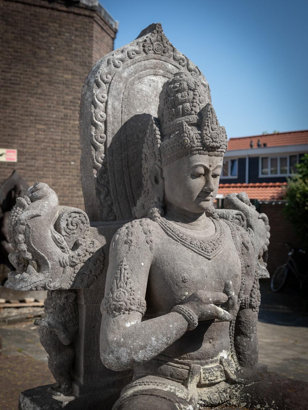 The very large old lavastone figure of Bodhisattva Avalokiteshvara is a truly impressive and monumental work of art. Crafted from lavastone, a material that holds cultural and geological significance in Indonesia, this statue stands at an