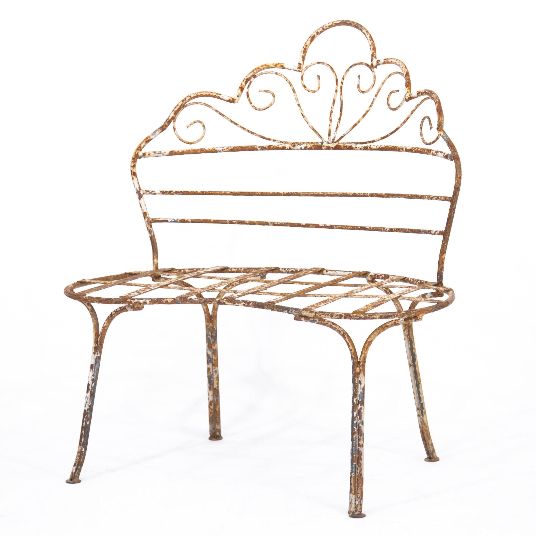 Victorian-style wrought iron garden chair or bench with curved seat and back, circa 1960s. It is very sturdy with an open and airy design featuring a scalloped, scrolled back and ample kidney-shaped seat. The original white painted finish is