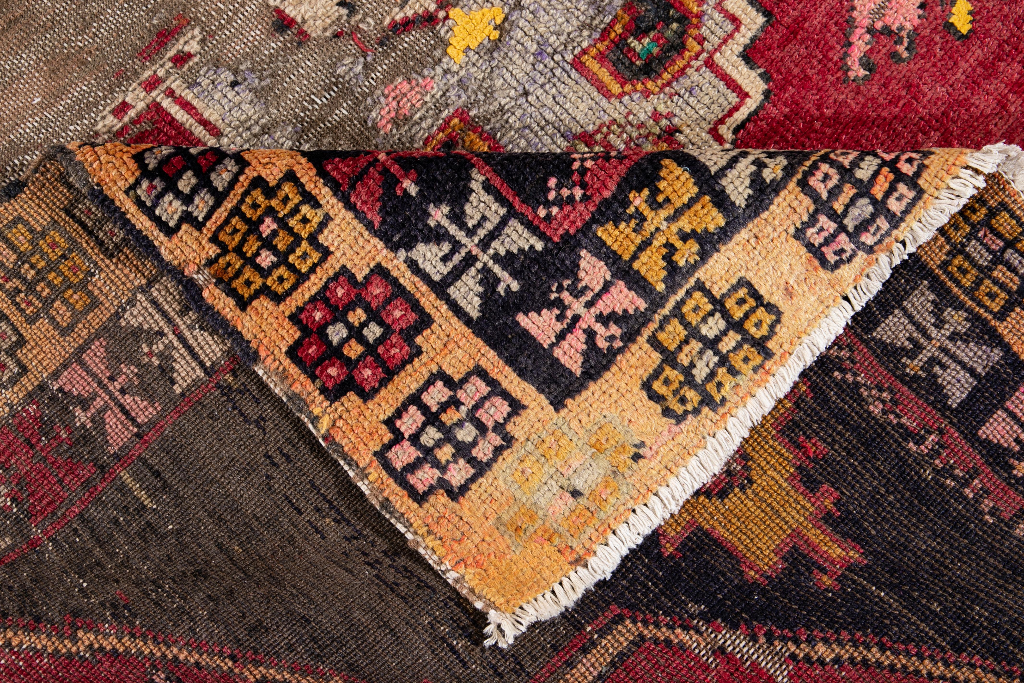 A hand knotted vintage Azeri runner with an artistic design on a red field, and multi-color accents throughout the piece.
This rug measures 5'3